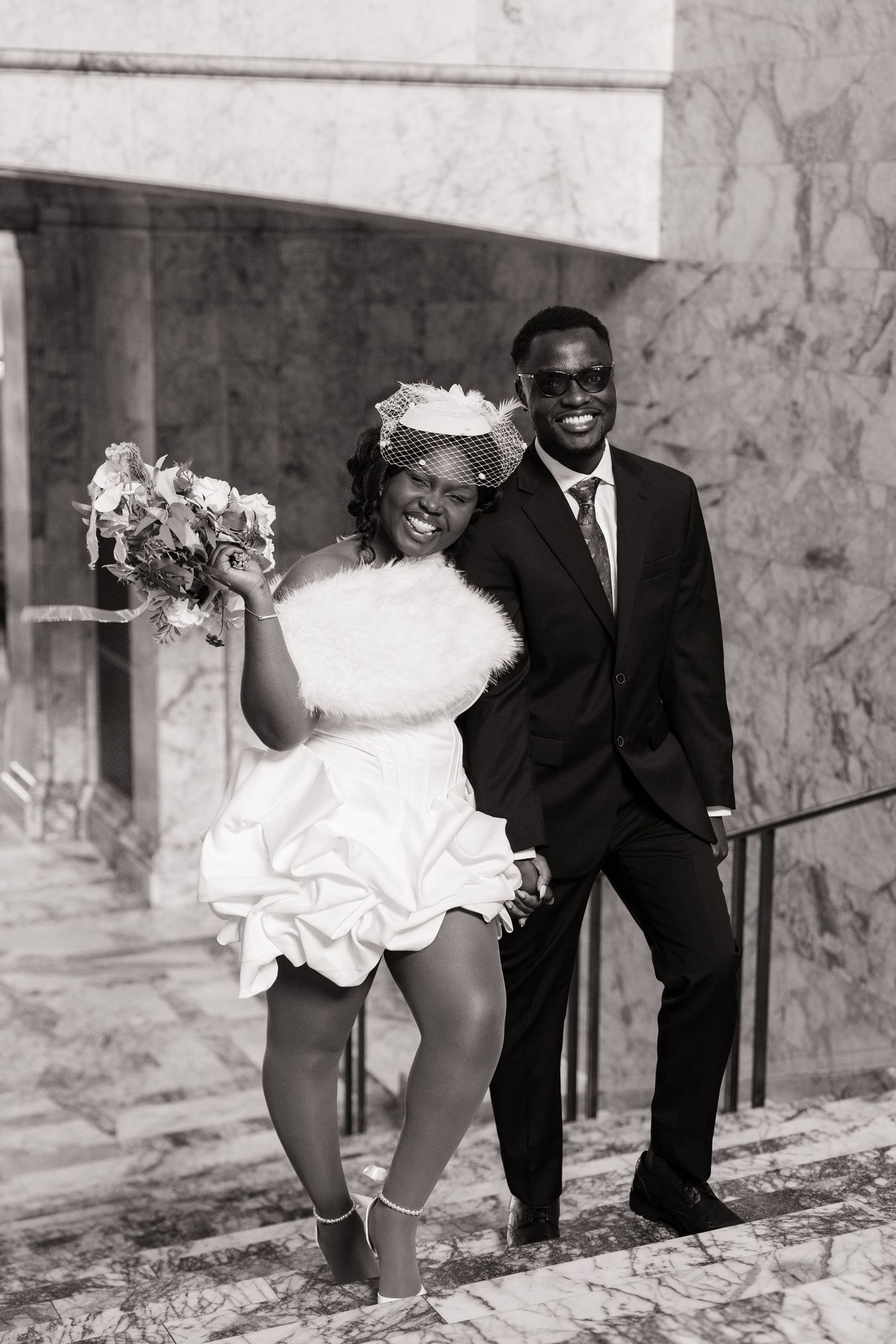 Newlyweds smiling together on the marble stairs inside the Washington State Capitol in Olympia