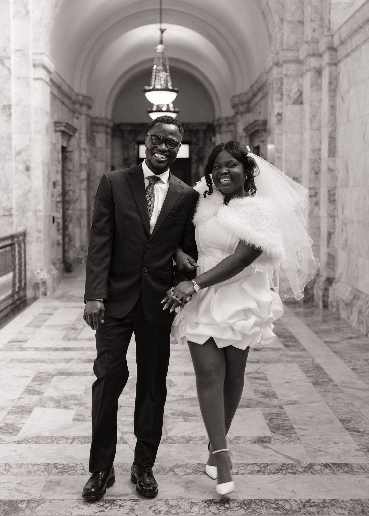 Candid black and white photo of newlyweds walking through the Washington State Capitol
