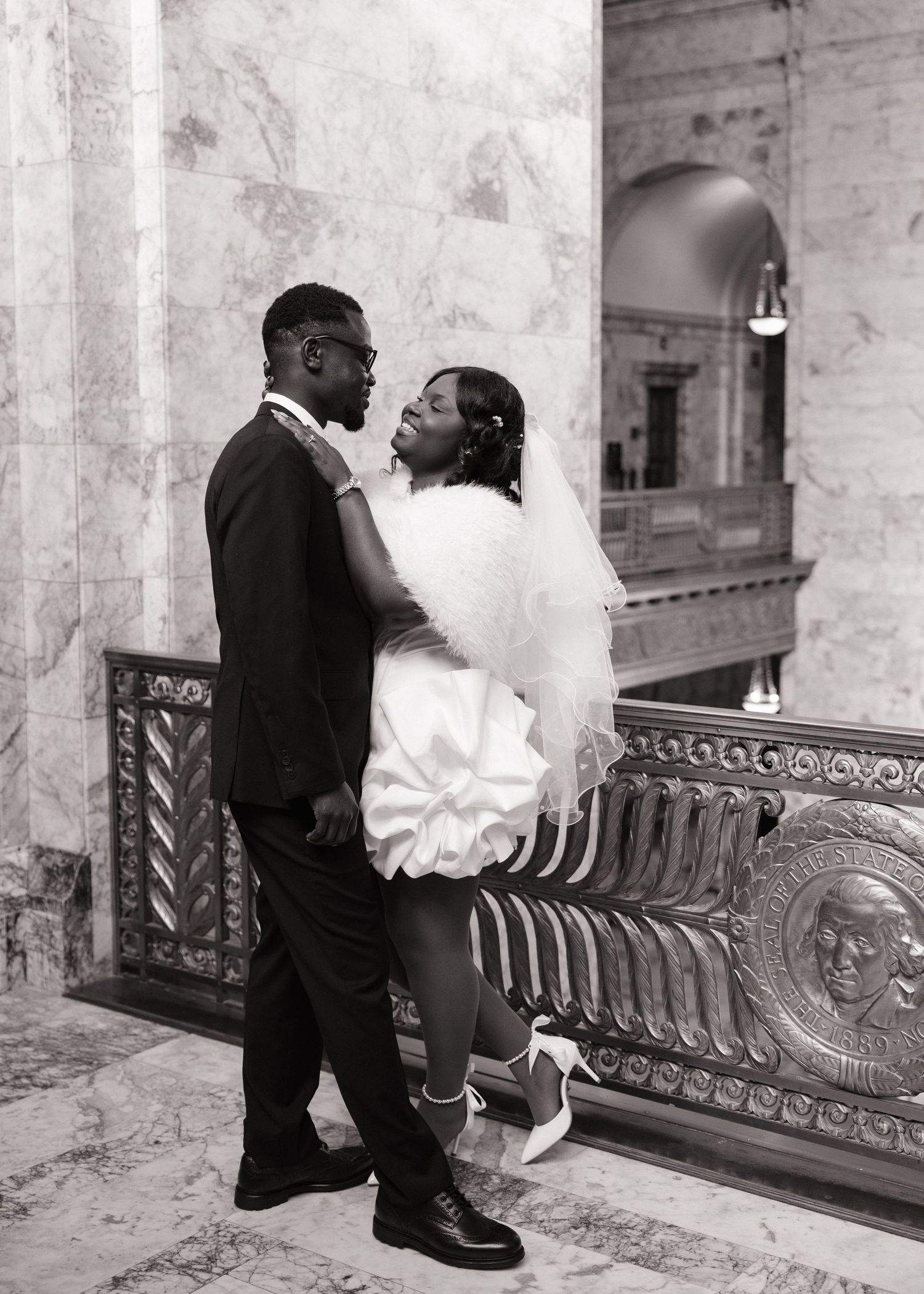 Bride and groom sharing a playful moment inside the Washington State Capitol in Olympia