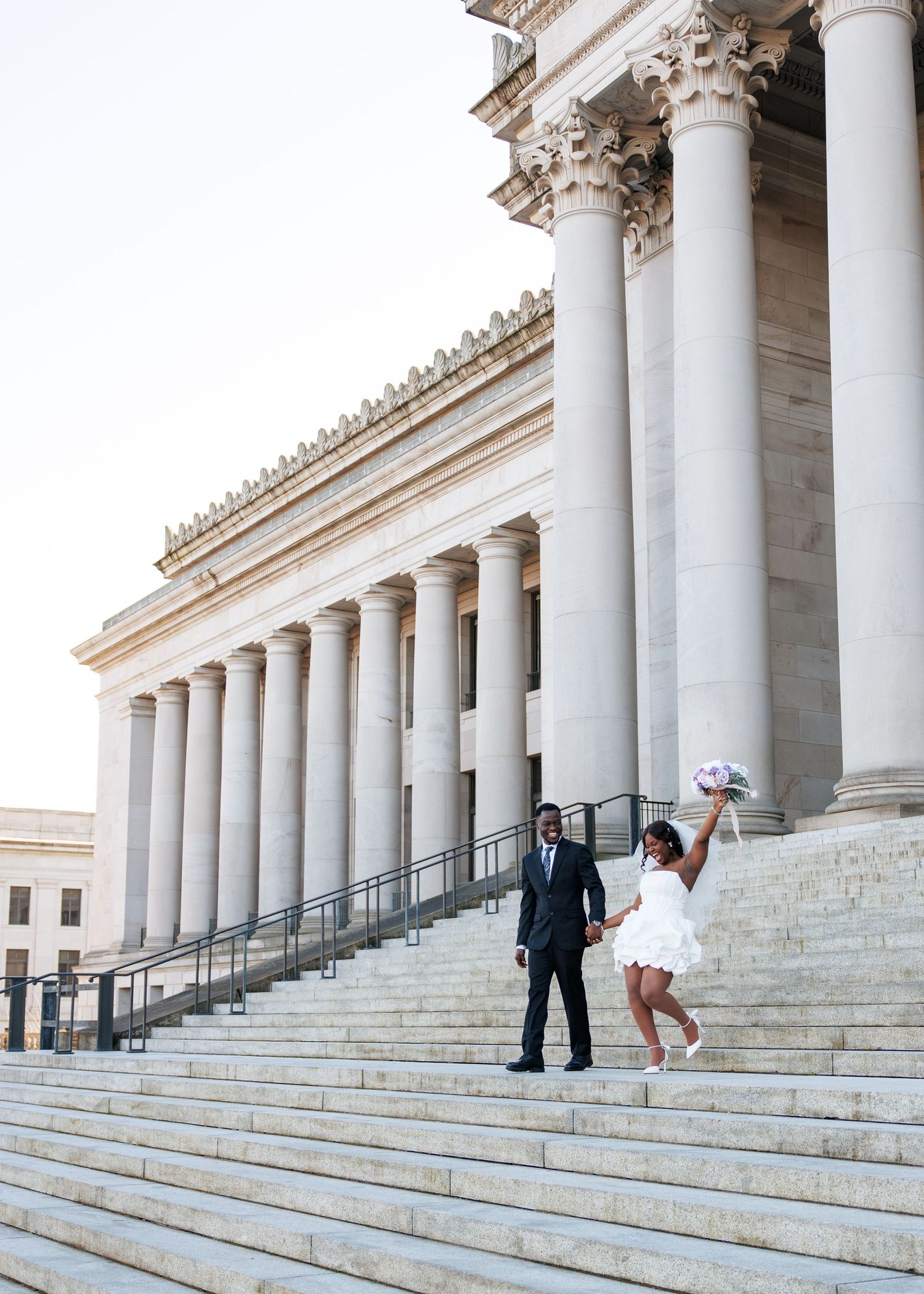 Bride and groom celebrating on the steps of the Washington State Capitol in Olympia