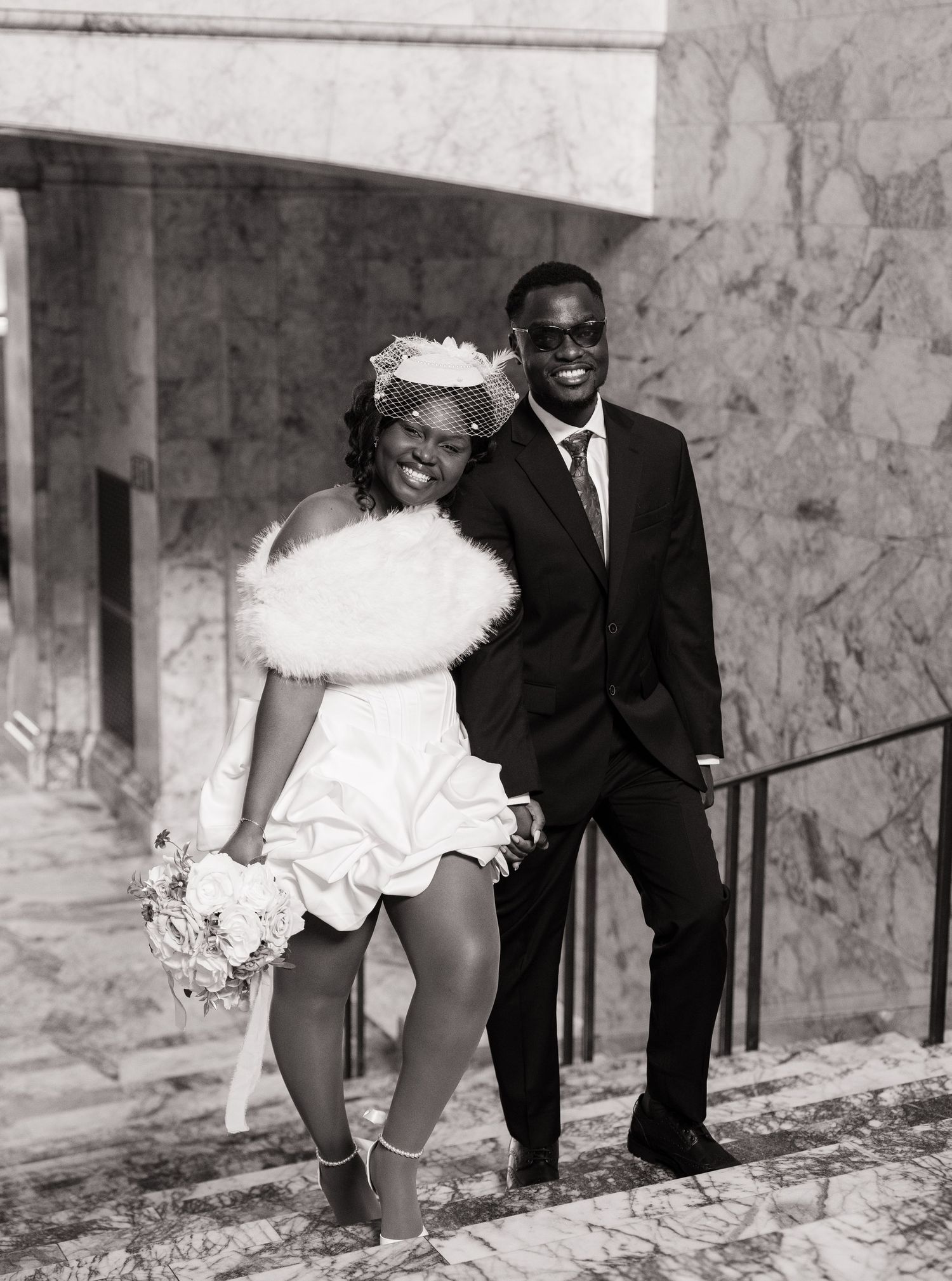 Newlyweds laughing together on the marble stairs inside the Washington State Capitol in Olympia