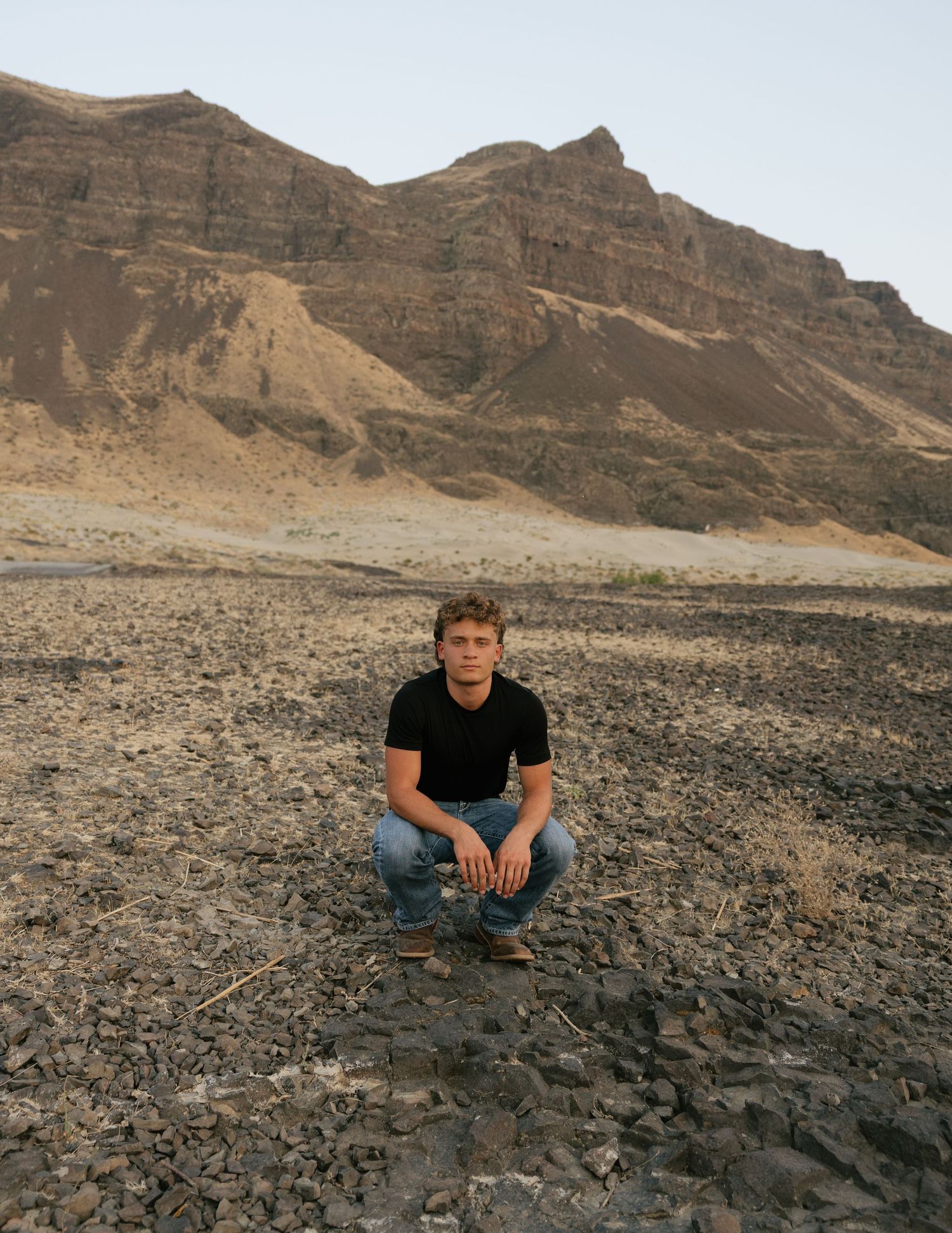 High school senior posing in a rugged mountain landscape during an adventurous Washington senior photography session.