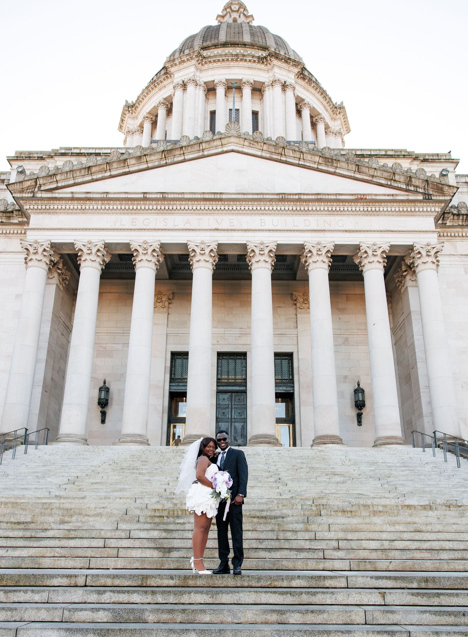 Newlyweds sharing a romantic moment in front of the Washington State Capitol in Olympia
