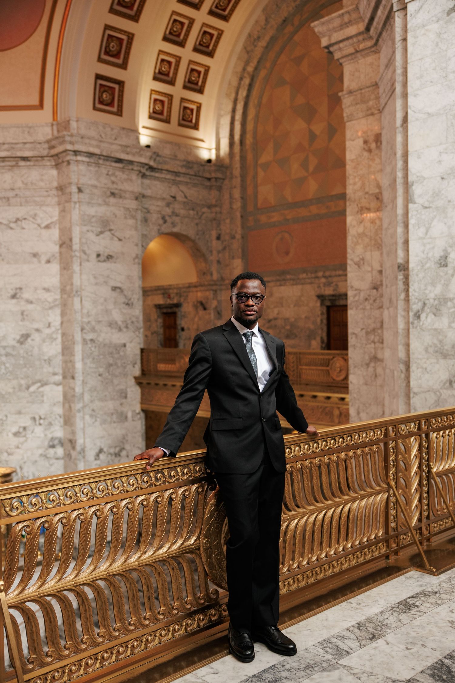 Groom posing beneath the grand architecture inside the Washington State Capitol