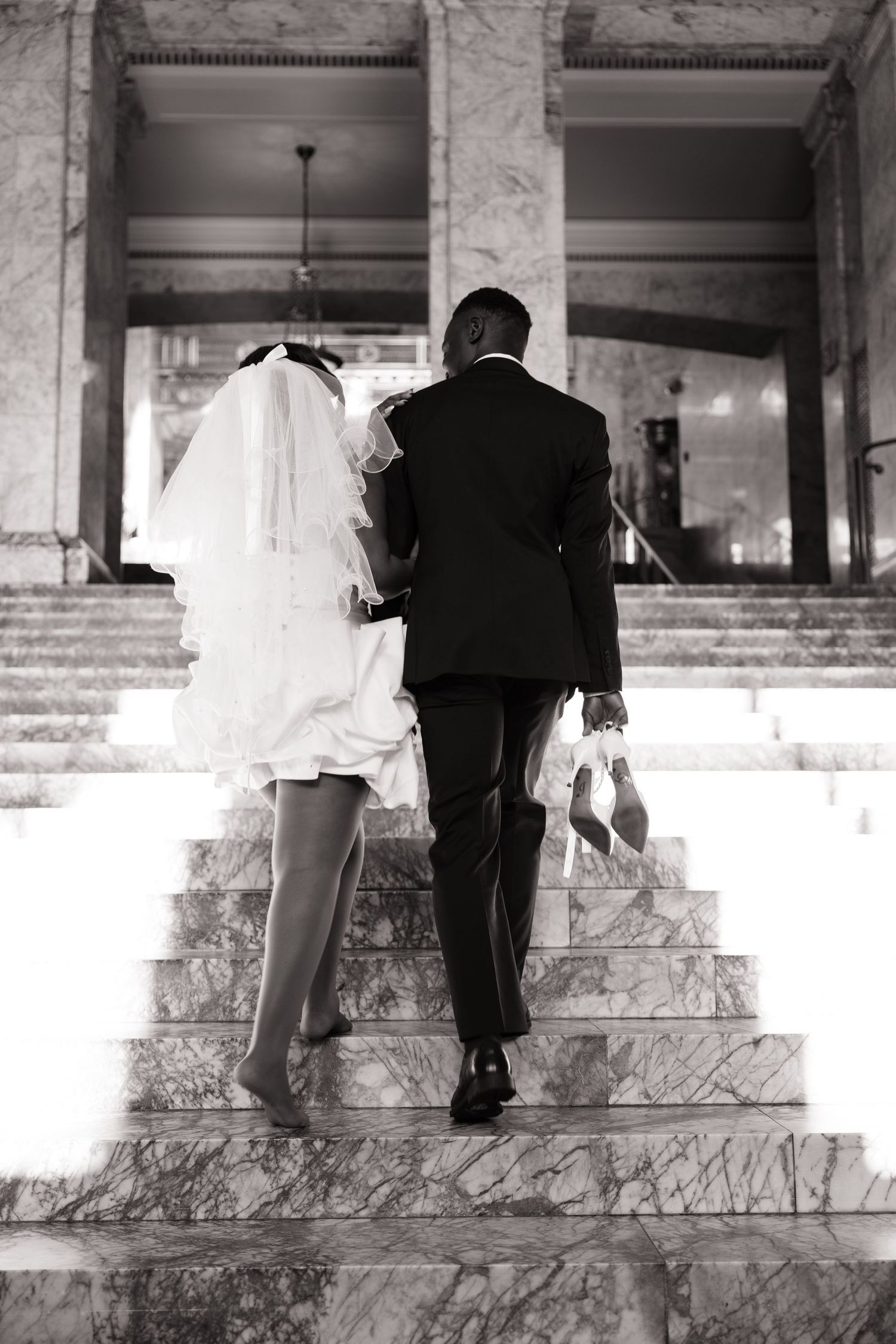 Newlyweds walking up the Washington State Capitol steps after their wedding