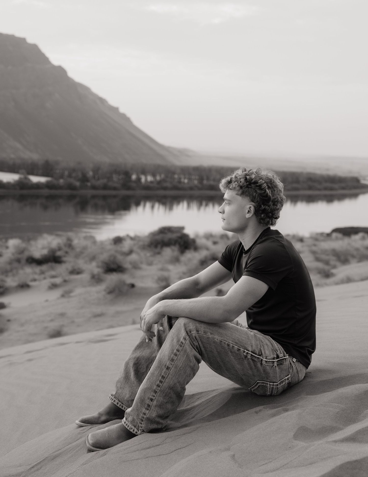 Black and white senior portrait overlooking the water and mountains during an outdoor Washington senior session.