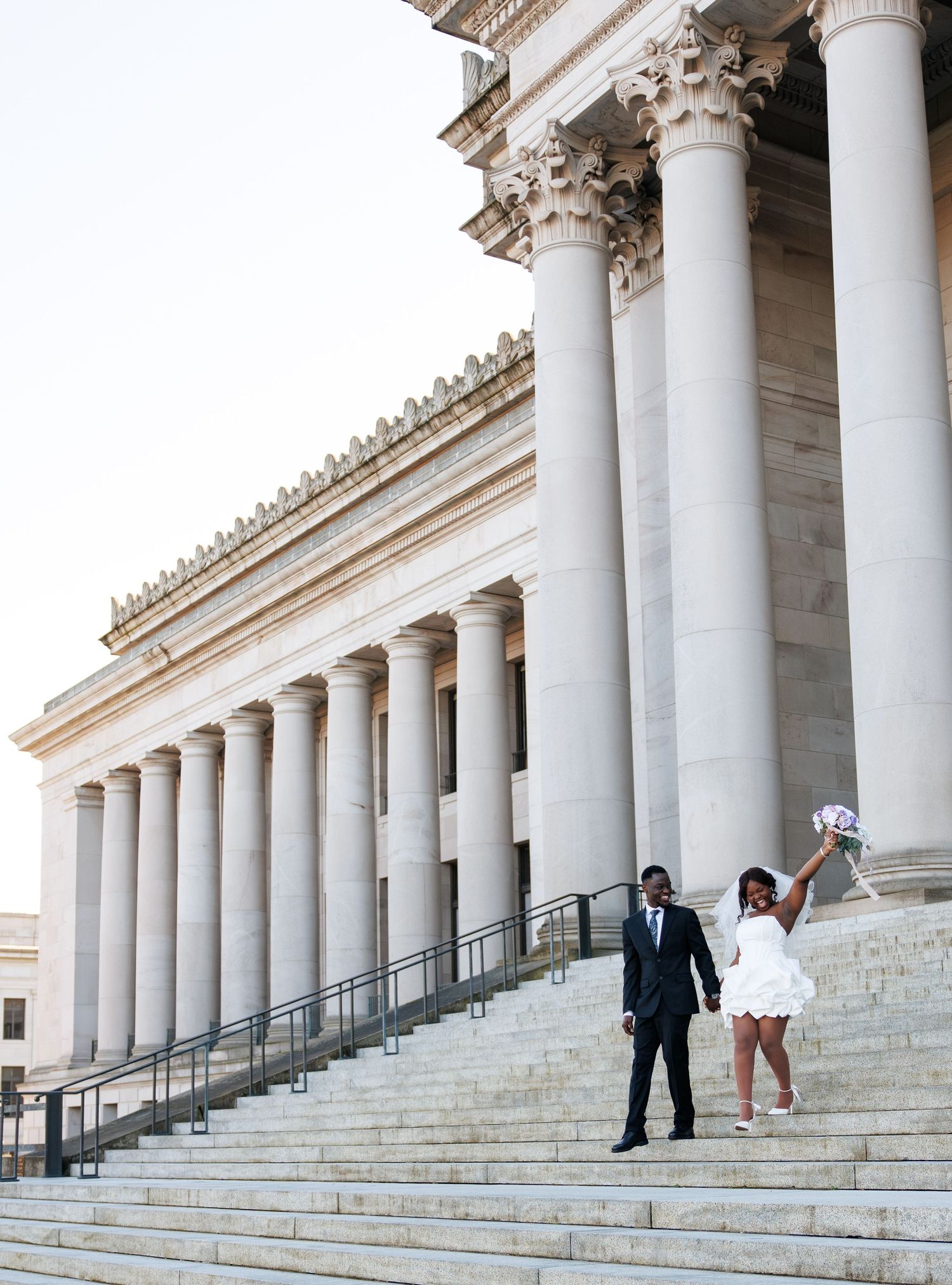 Newlyweds celebrating beneath the columns of the Washington State Capitol in Olympia