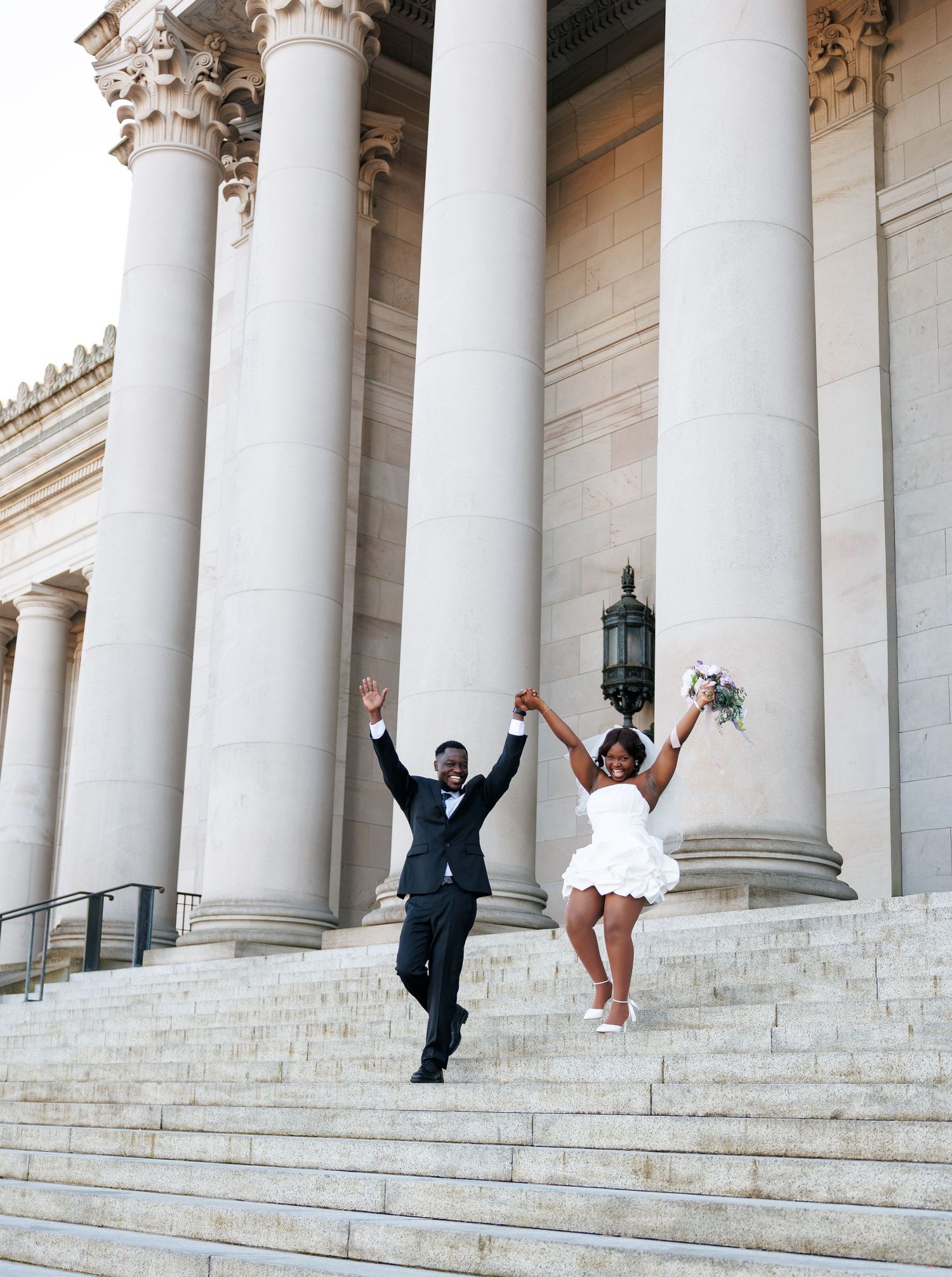 Newlyweds celebrating on the Washington State Capitol steps after their Olympia wedding