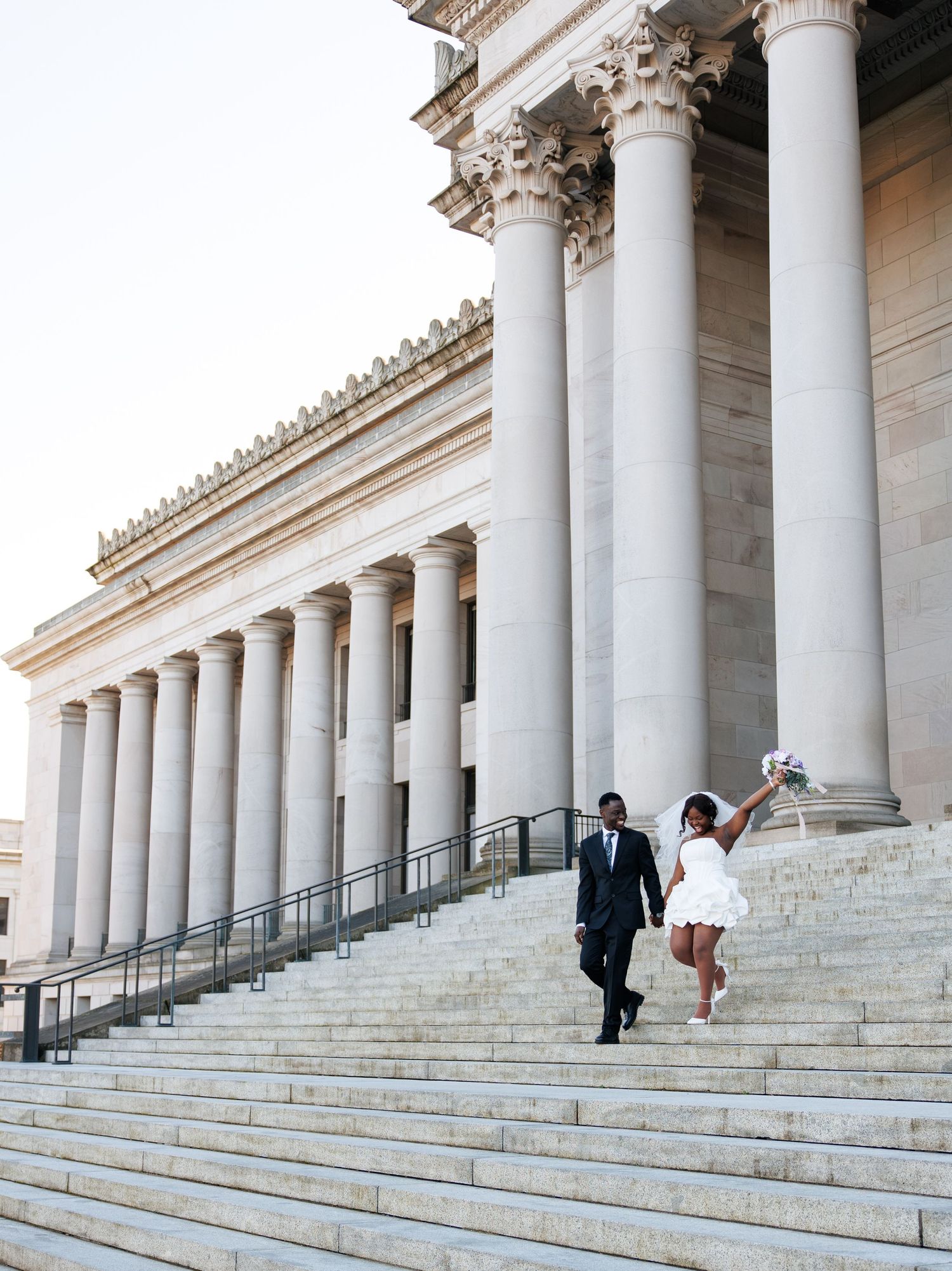 Newlyweds walking down the Washington State Capitol steps during their Olympia wedding