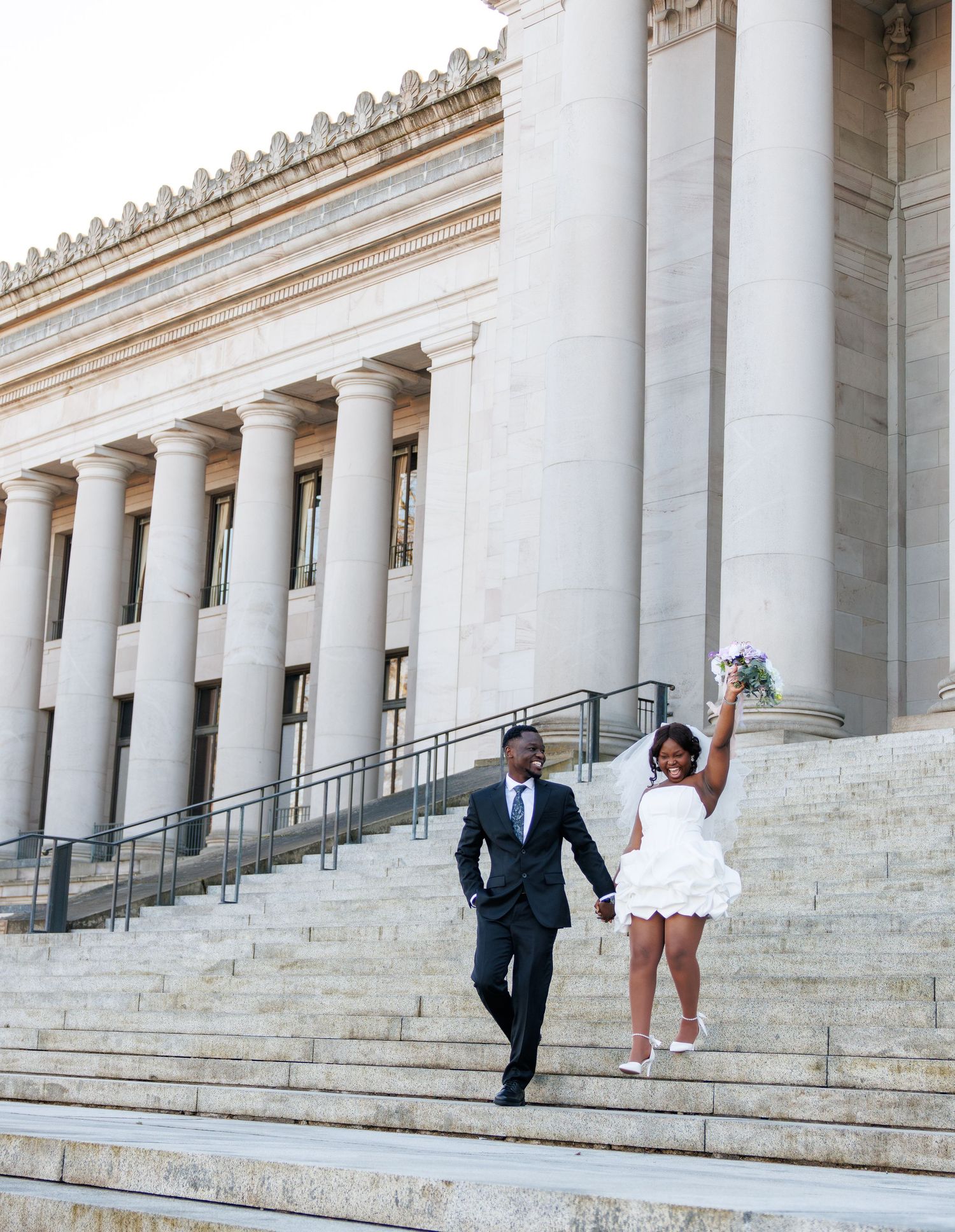 Bride and groom walking down the Washington State Capitol steps after their Olympia wedding