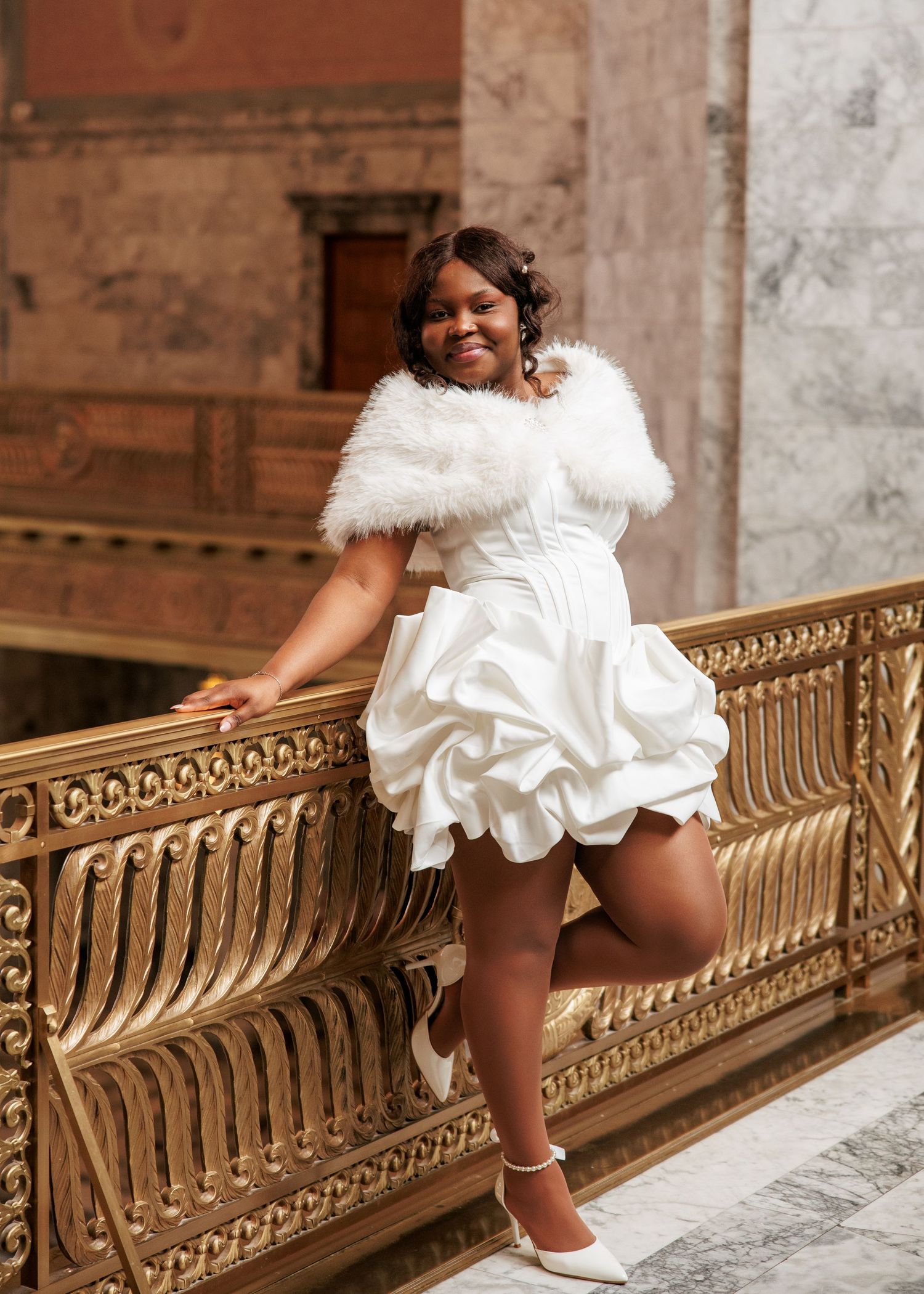 Bride posing in her wedding dress beside the ornate Capitol railing in Olympia