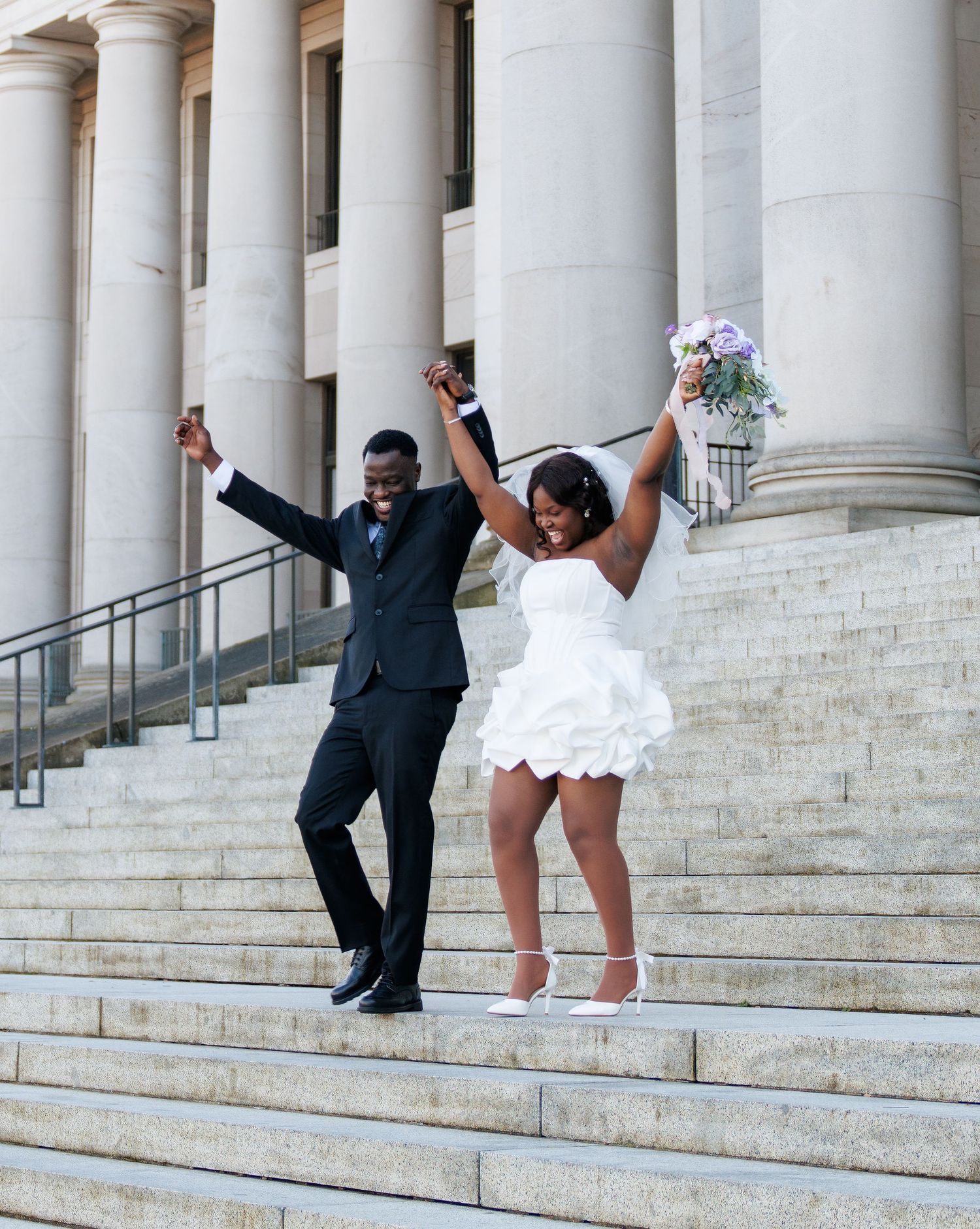 Joyful bride and groom celebrating together on the Washington State Capitol steps