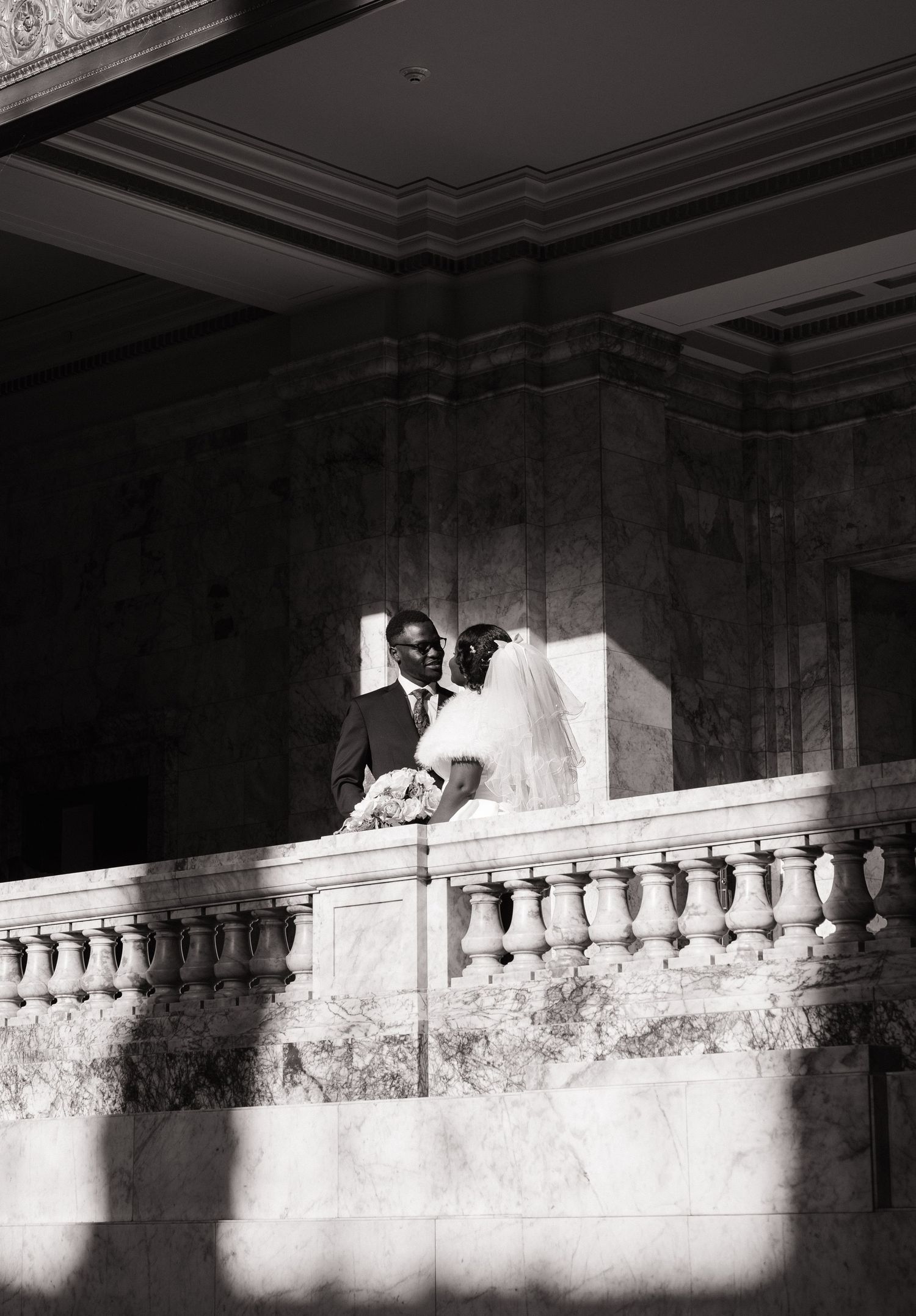 Newlyweds sharing a candid moment on a Washington State Capitol balcony in Olympia