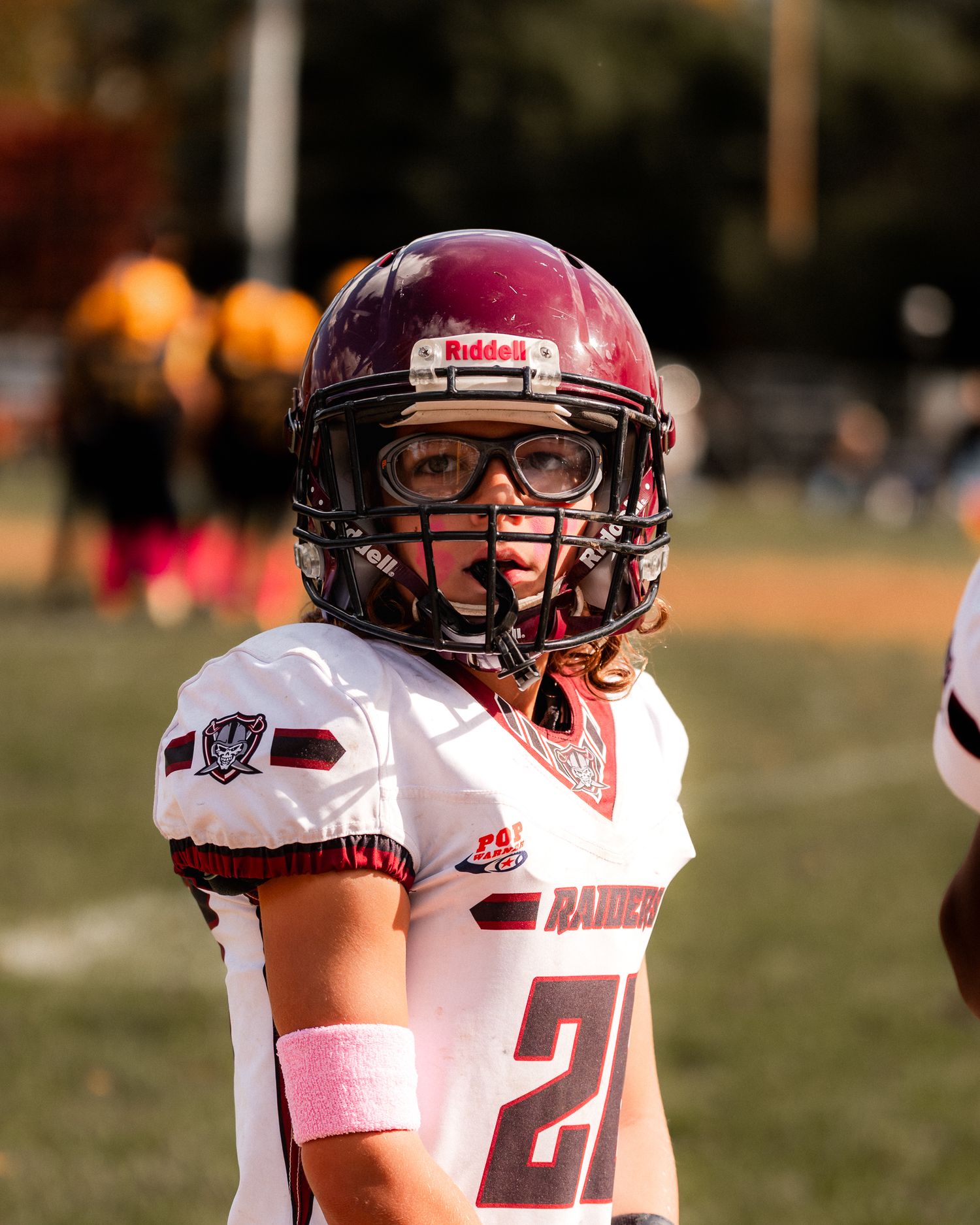 Football player staring off into the distance in full football uniform.