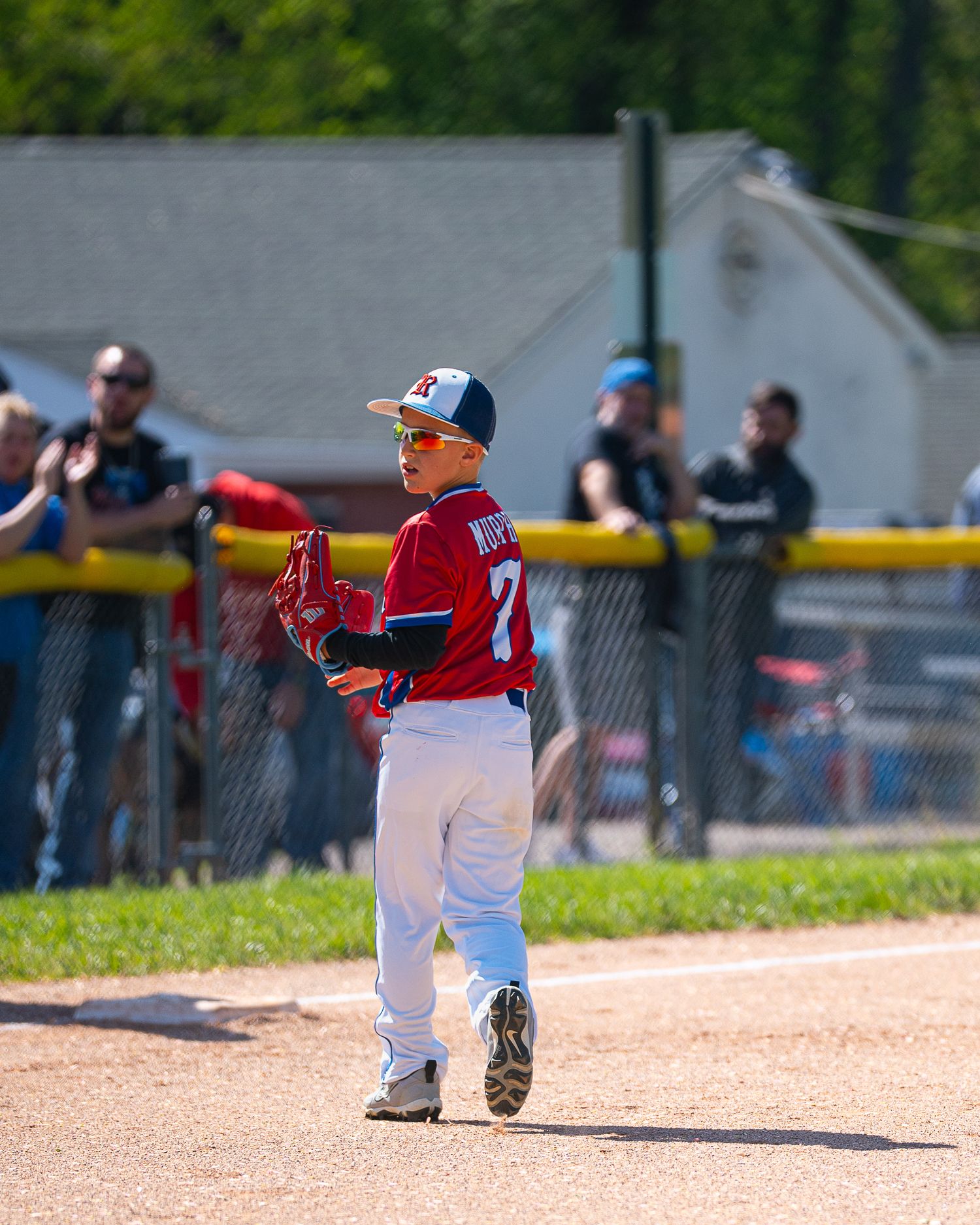 Baseball player walking back to his position and looking back at the camera.