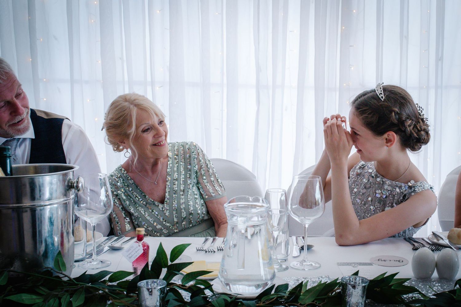 Wedding guests sharing a joyful moment at the reception dinner table.