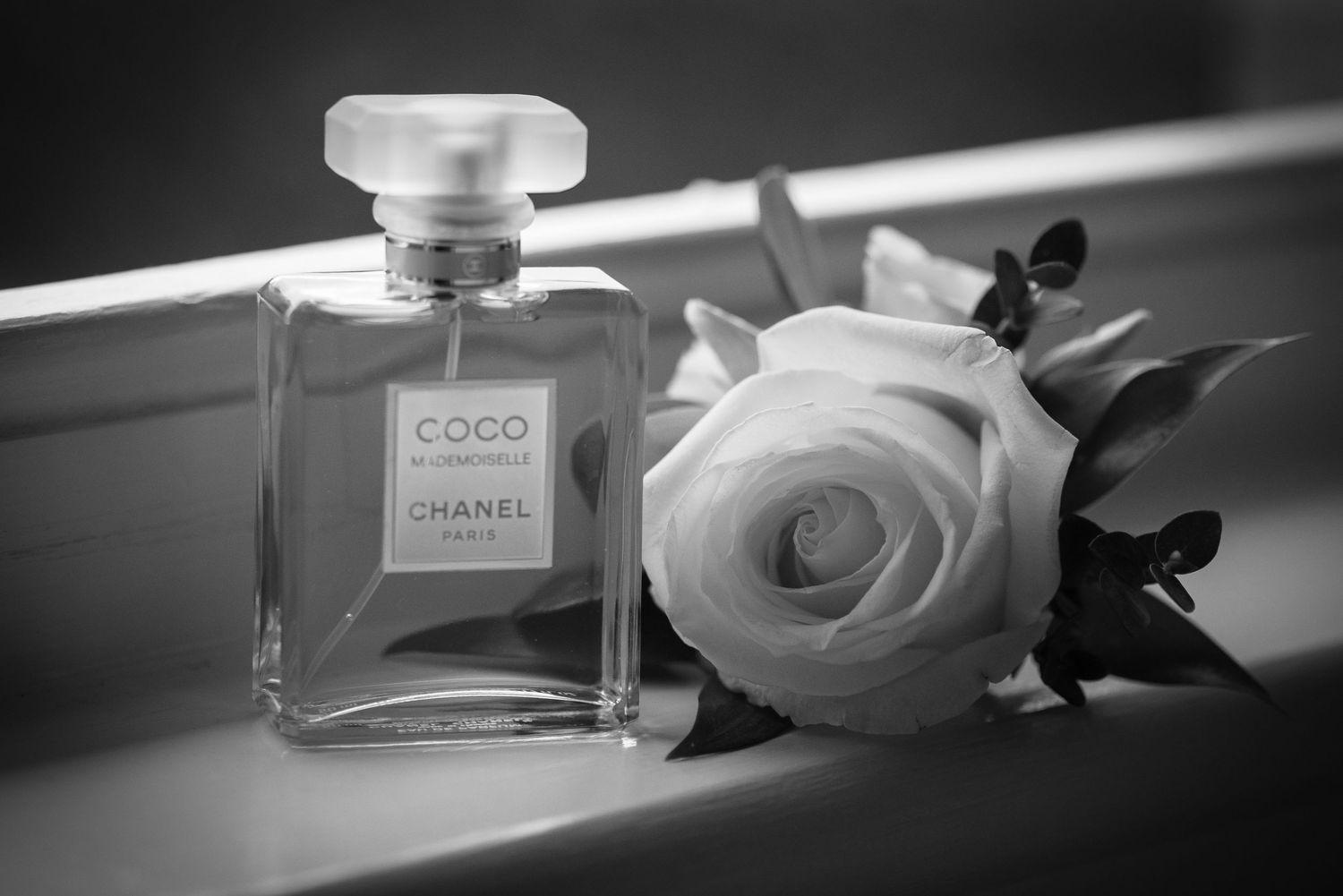 Coco Chanel Mademoiselle perfume bottle with a white rose in black and white.