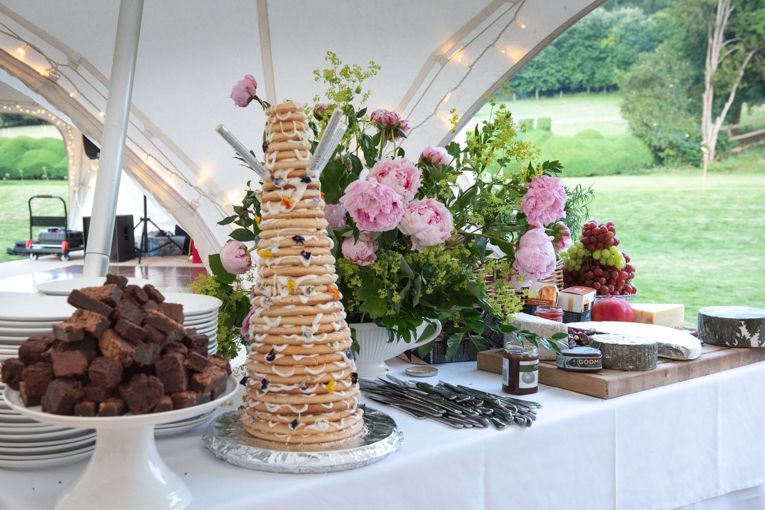 Elegant wedding dessert table featuring a traditional Norwegian kransekake tower with pink floral arrangements.