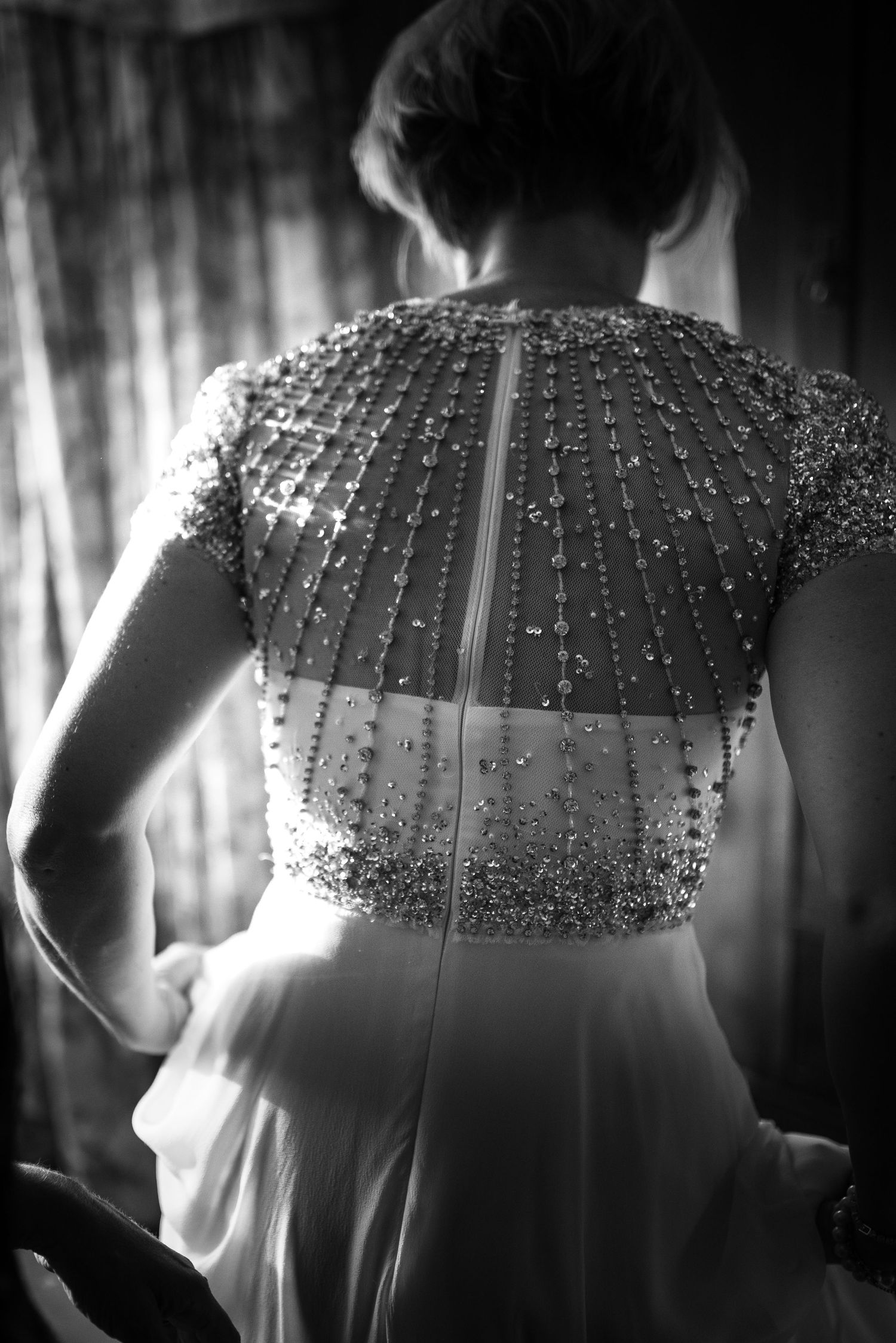Close-up black and white detail of intricate beaded and embellished wedding dress bodice back.