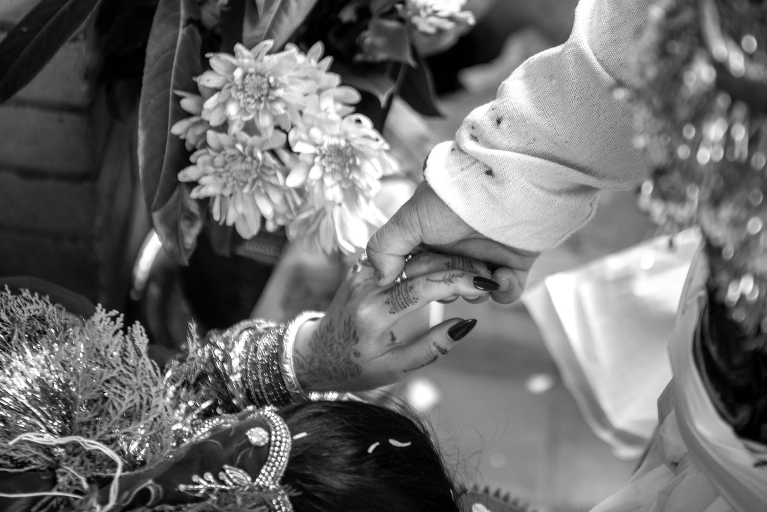 Black and white image of bride receiving traditional blessing during cultural South Asian wedding ceremony.