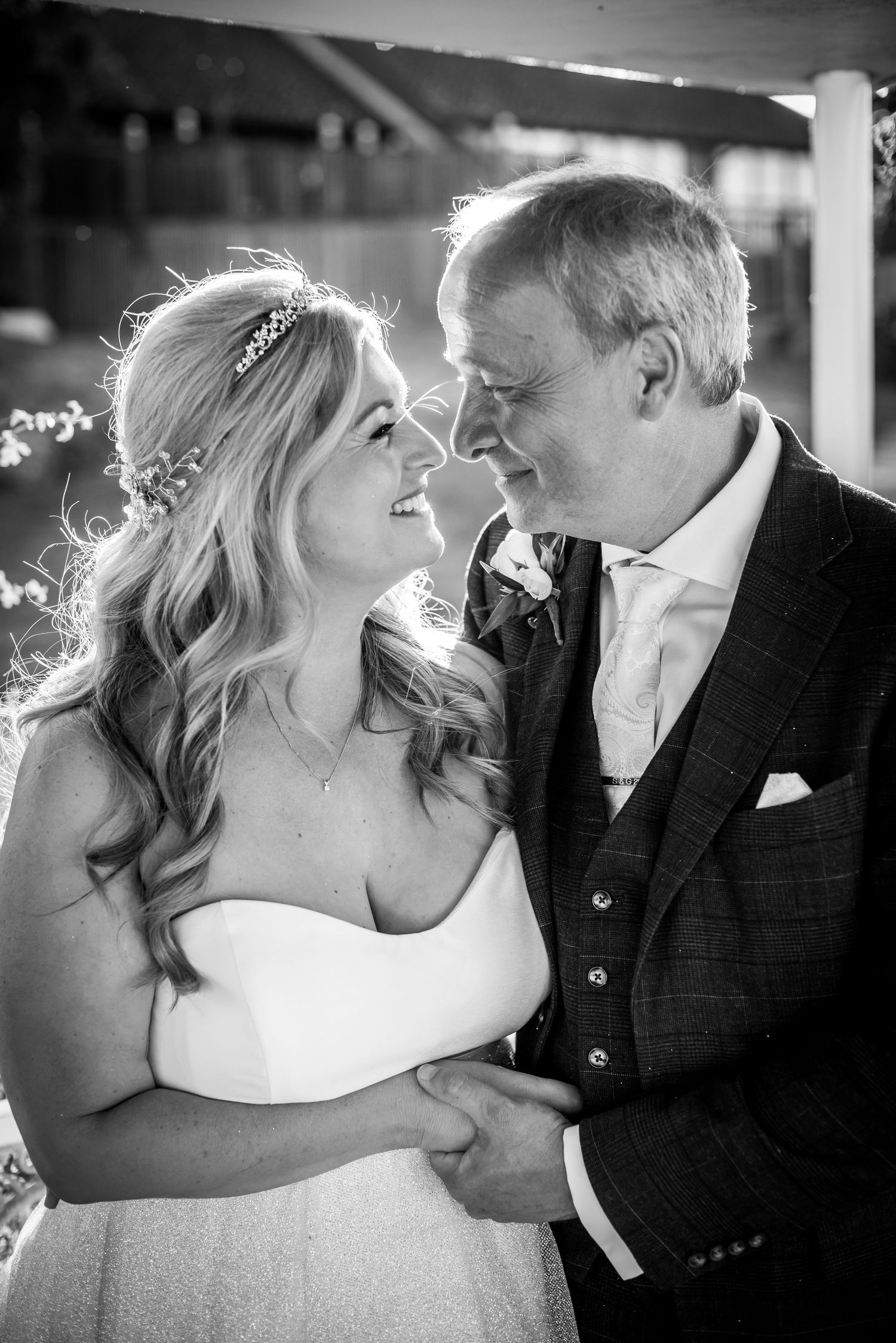 Black and white photo of bride and groom gazing lovingly at each other on their wedding day.