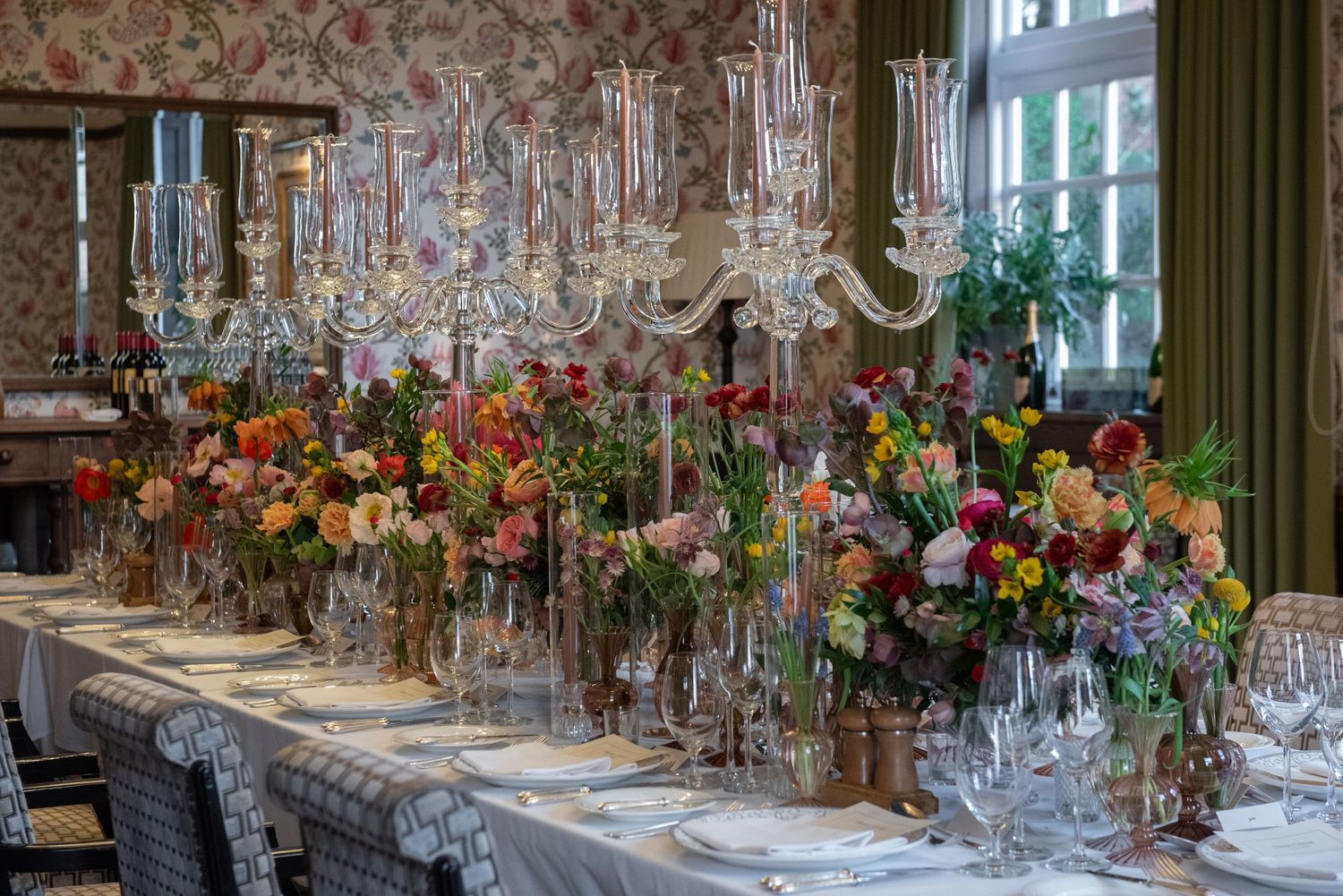Formal dining table decorated with tall crystal candelabras and vibrant mixed floral arrangements.  Private dining Four Seasons Hampshire