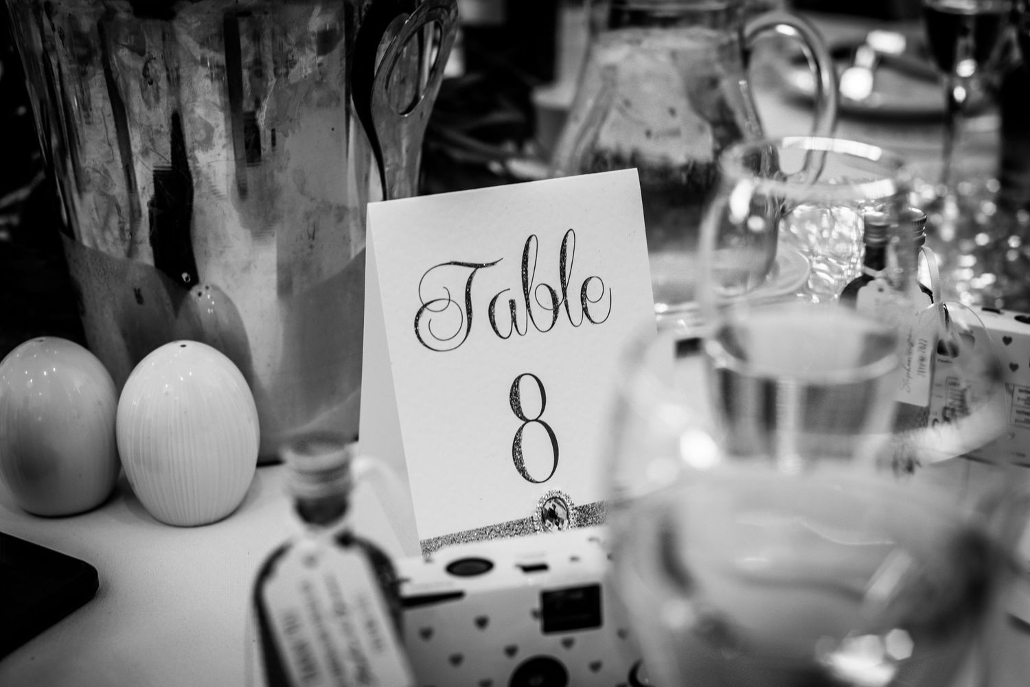 Black and white wedding reception table number eight sign with elegant decorations.