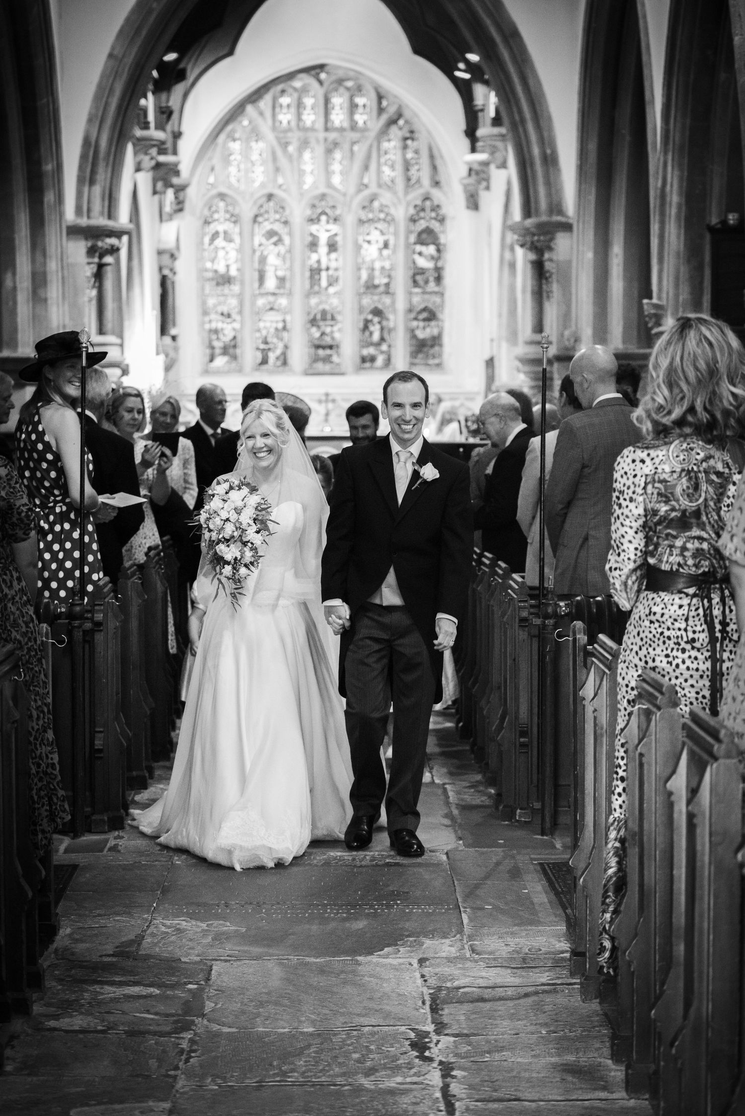 Bride and groom walk hand in hand down the aisle of a historic church after their wedding ceremony. St Michaels church bray.
