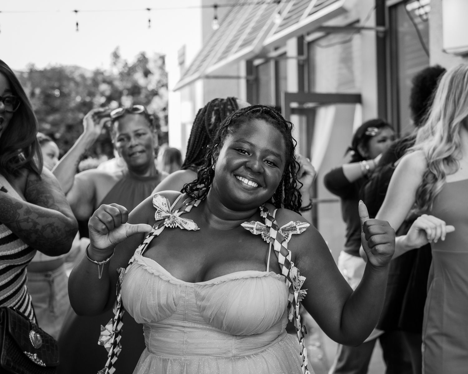 Joyful woman in a dress smiling and dancing at an outdoor celebration event.