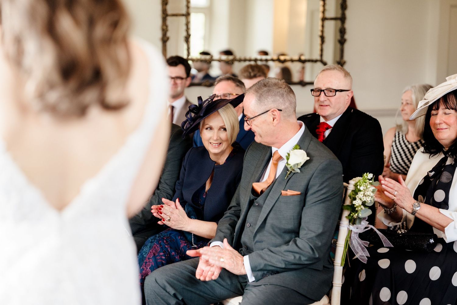 Wedding guests smiling and reacting emotionally during the marriage ceremony.