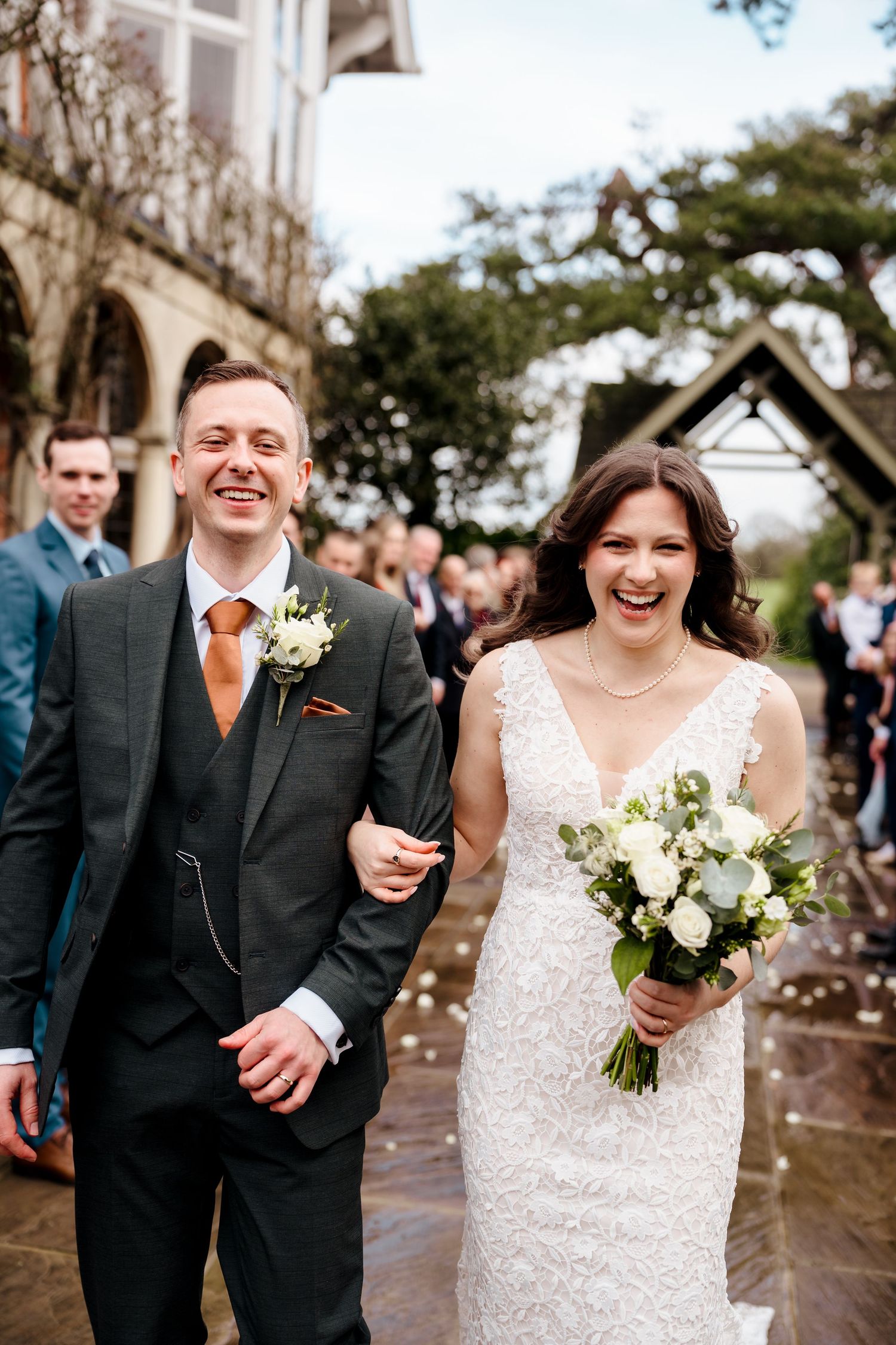 Joyful bride and groom walking back down the aisle through confetti after their wedding.