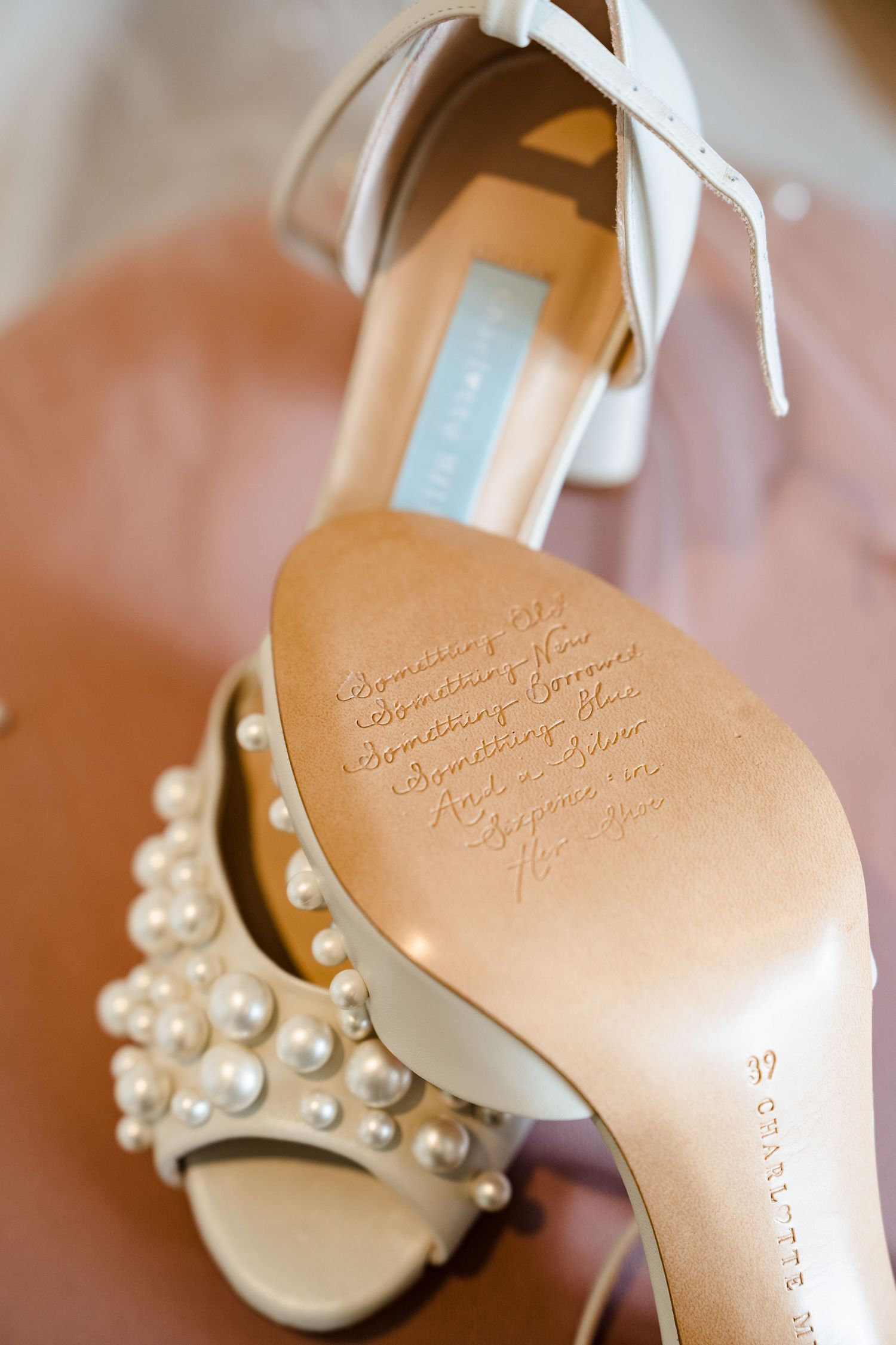 White pearl-embellished wedding heels with handwritten vows on the sole, elegant bridal shoes detail.
