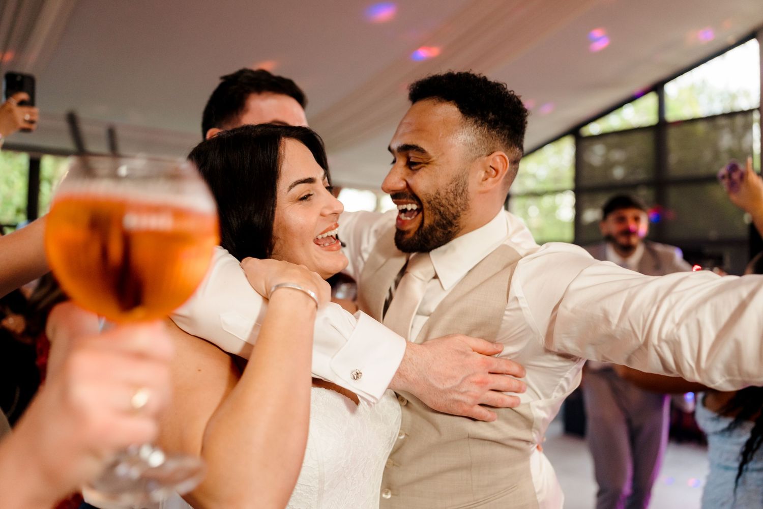 Bride and groom celebrate joyfully on the dance floor during their wedding reception party.