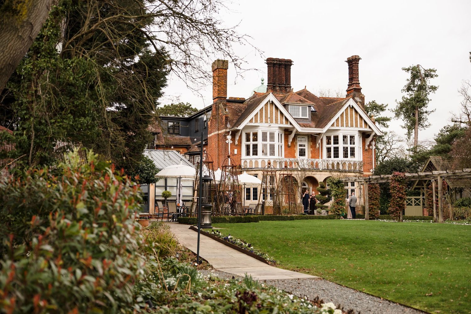 Beautiful Tudor-style English manor house wedding venue surrounded by lush green gardens.
