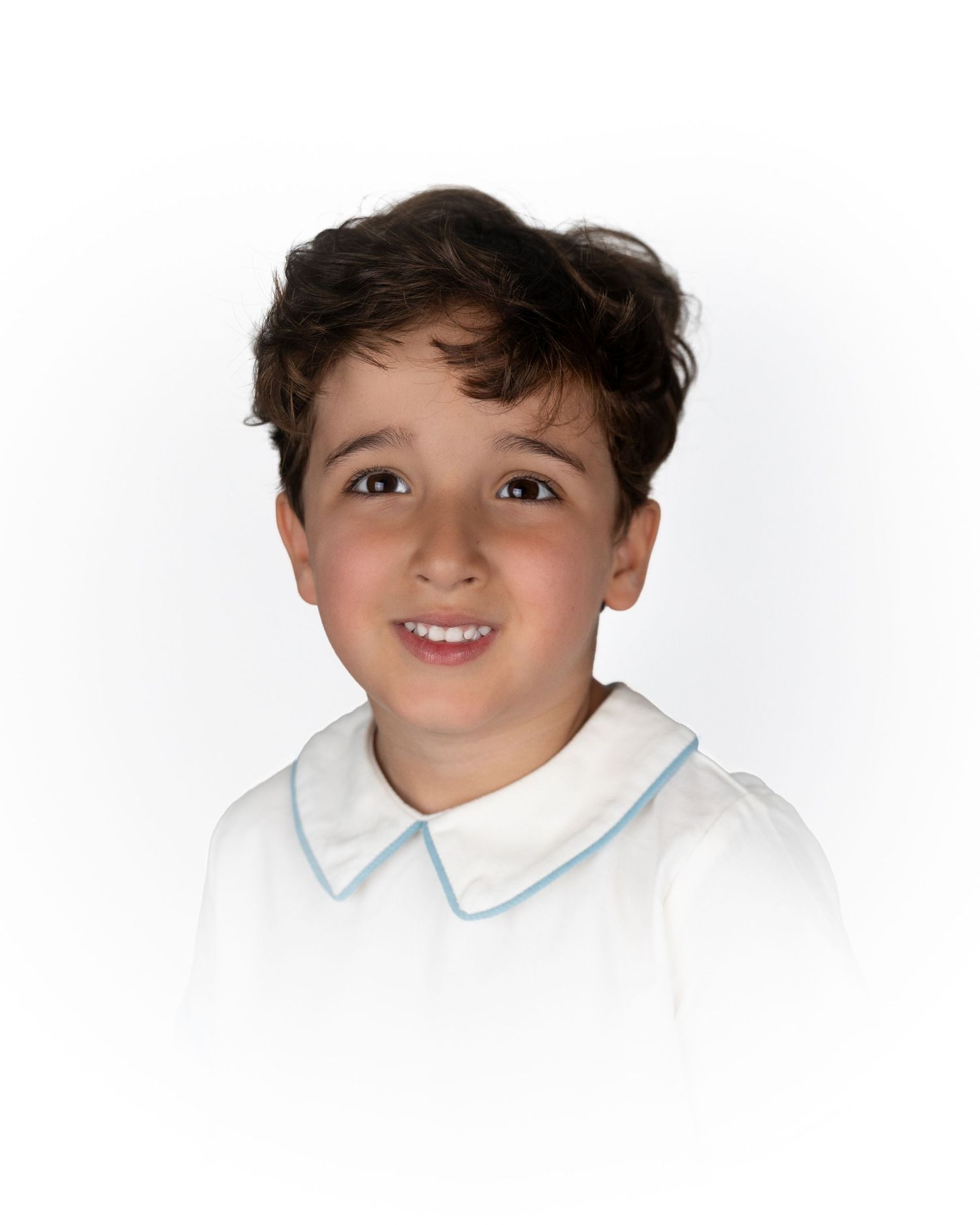 Smiling boy wearing a classic white shirt with a blue-edged Peter Pan collar.