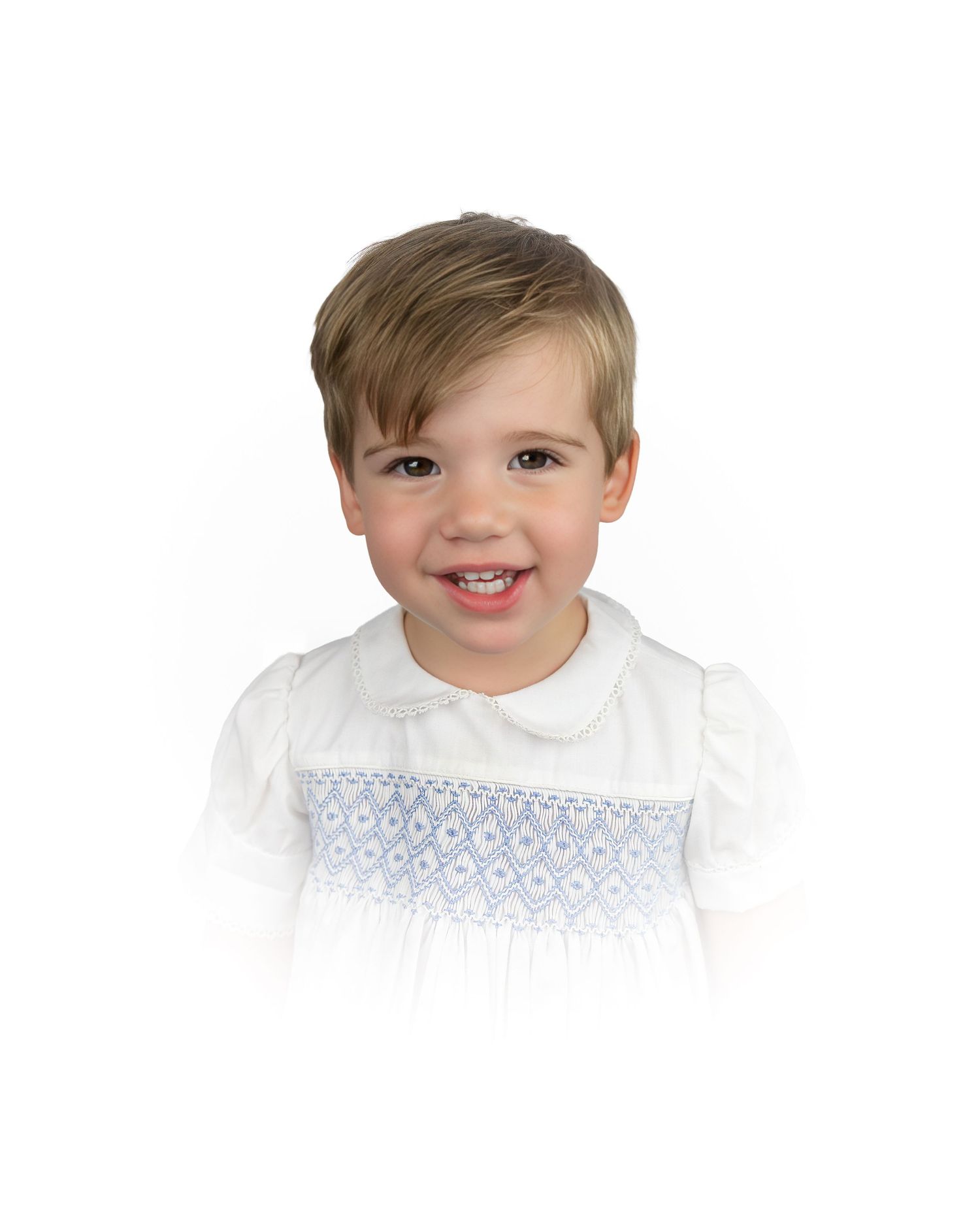 Young toddler in a white Peter Pan collar dress with blue smocking detail.