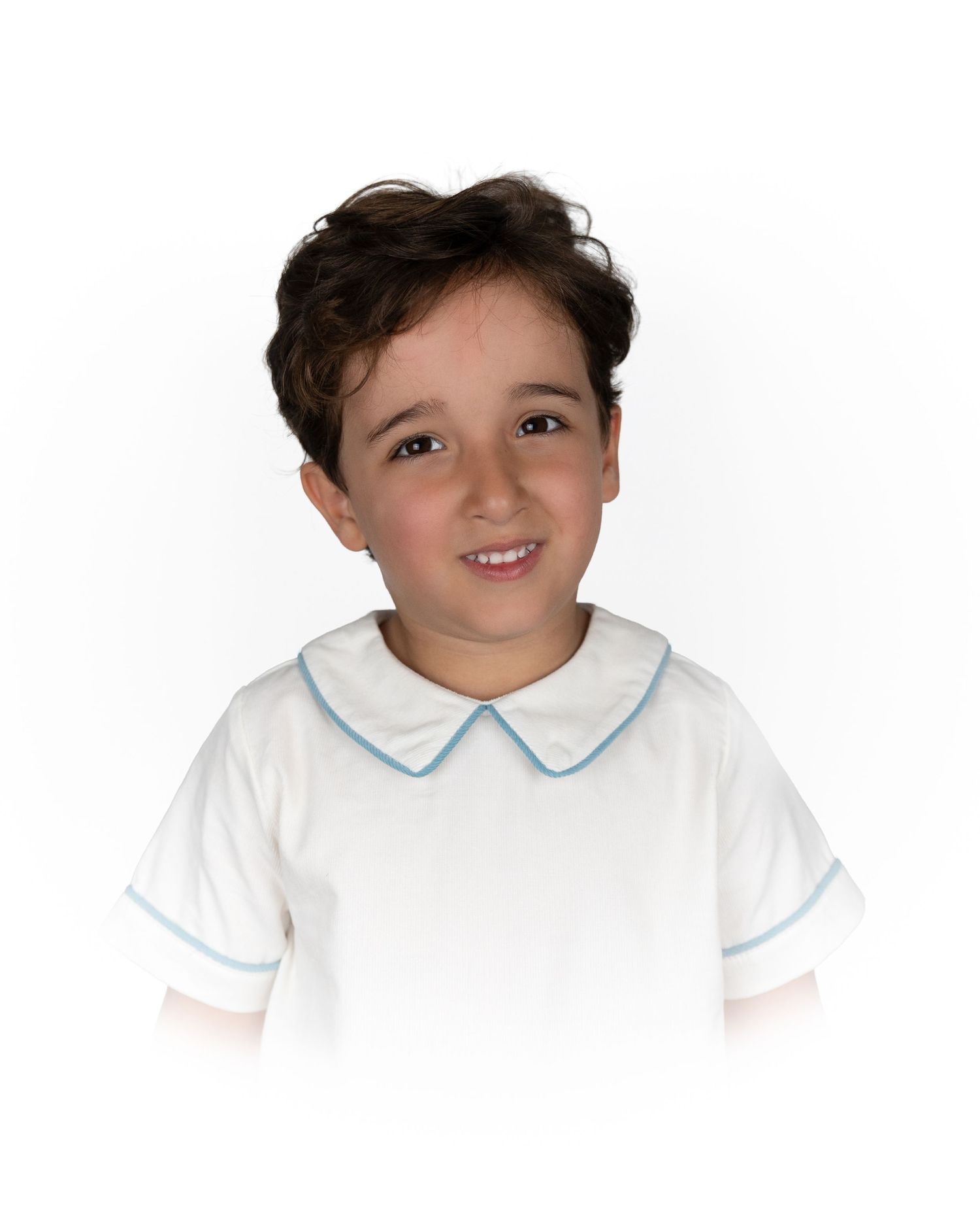 Cheerful boy modeling a white short-sleeve shirt with blue-trimmed Peter Pan collar.