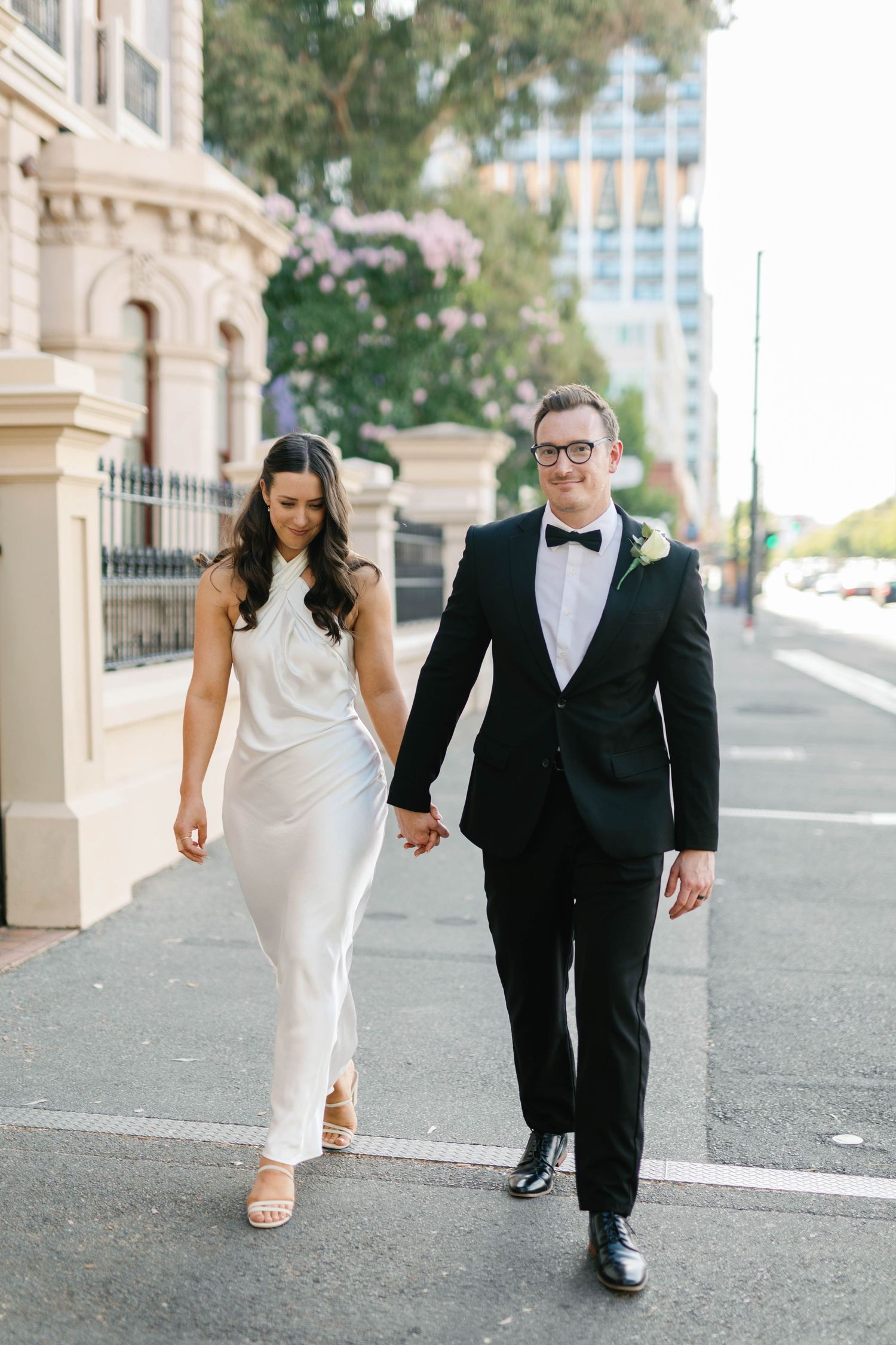Brooke and Lloyd walking towards the camera along North Terrace after their Adelaide elopement.