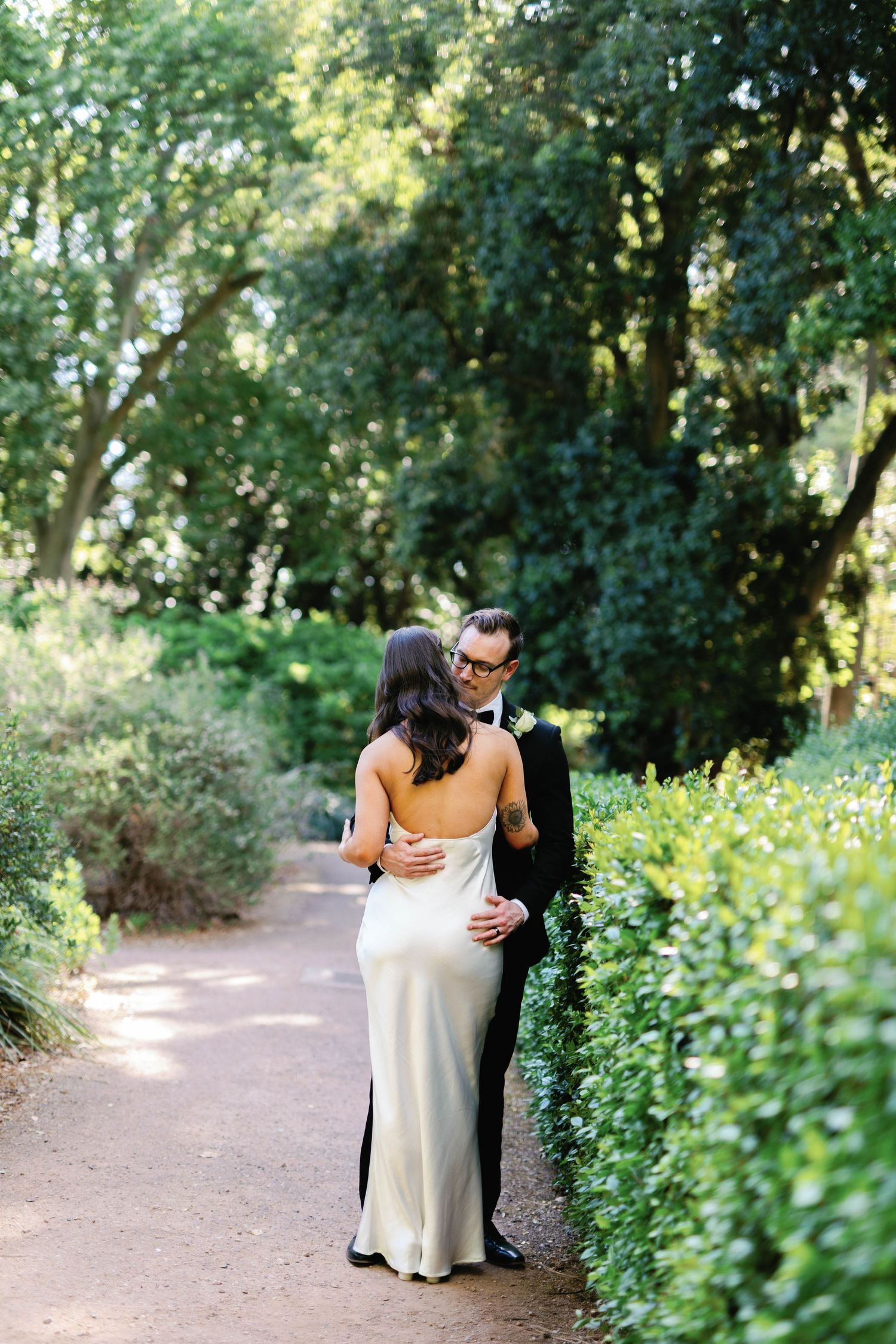Brooke and Lloyd standing together on a sunlit path at Adelaide Botanic Garden.