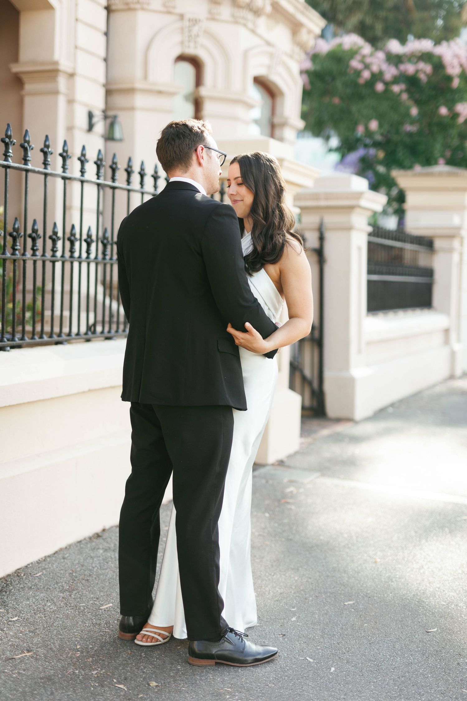Brooke and Lloyd sharing a moment beside an ornate fence on North Terrace