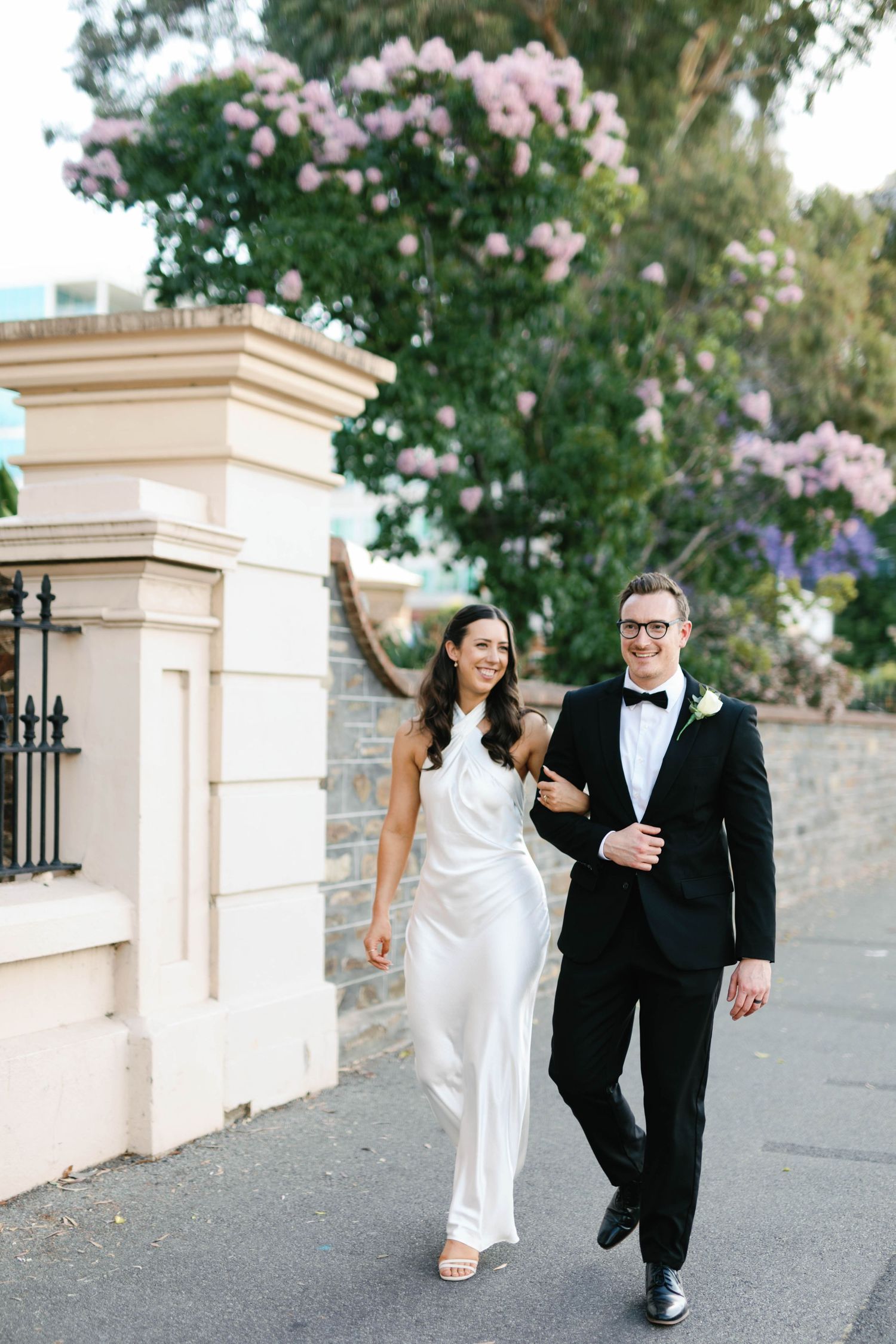 Brooke and Lloyd walking together beneath the trees on North Terrace.
