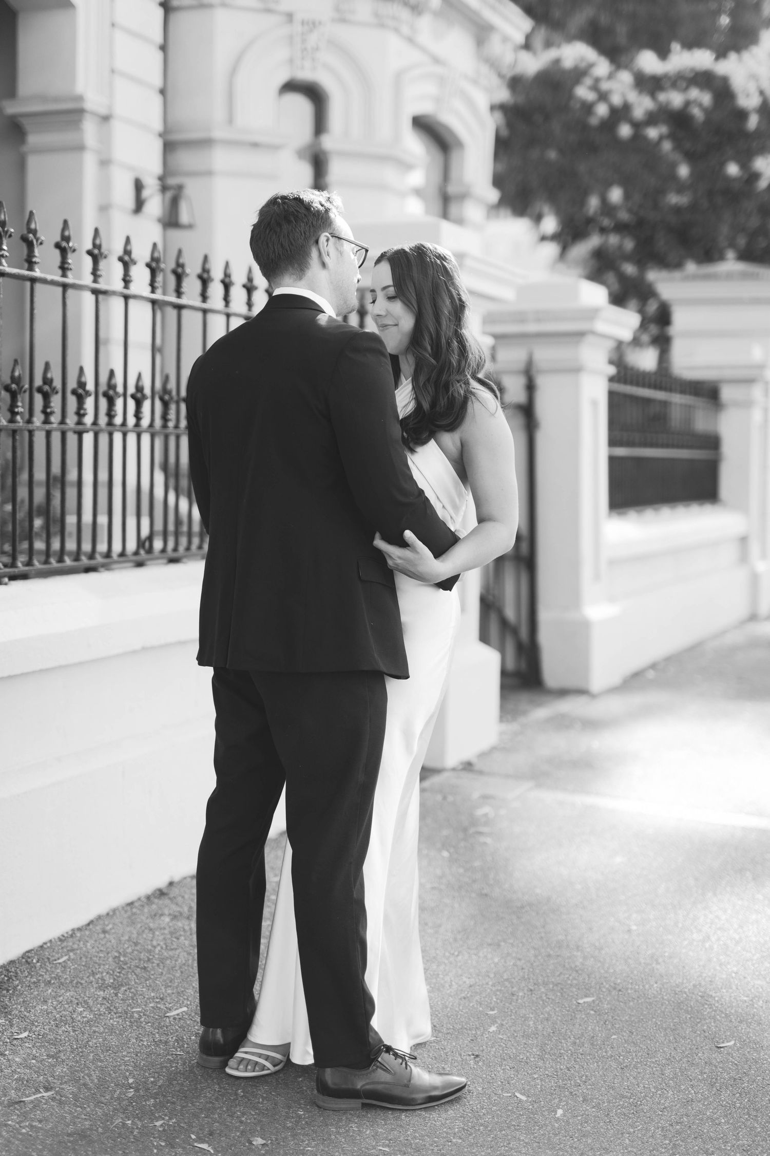 Black and white portrait of Brooke and Lloyd embracing on North Terrace, Adelaide