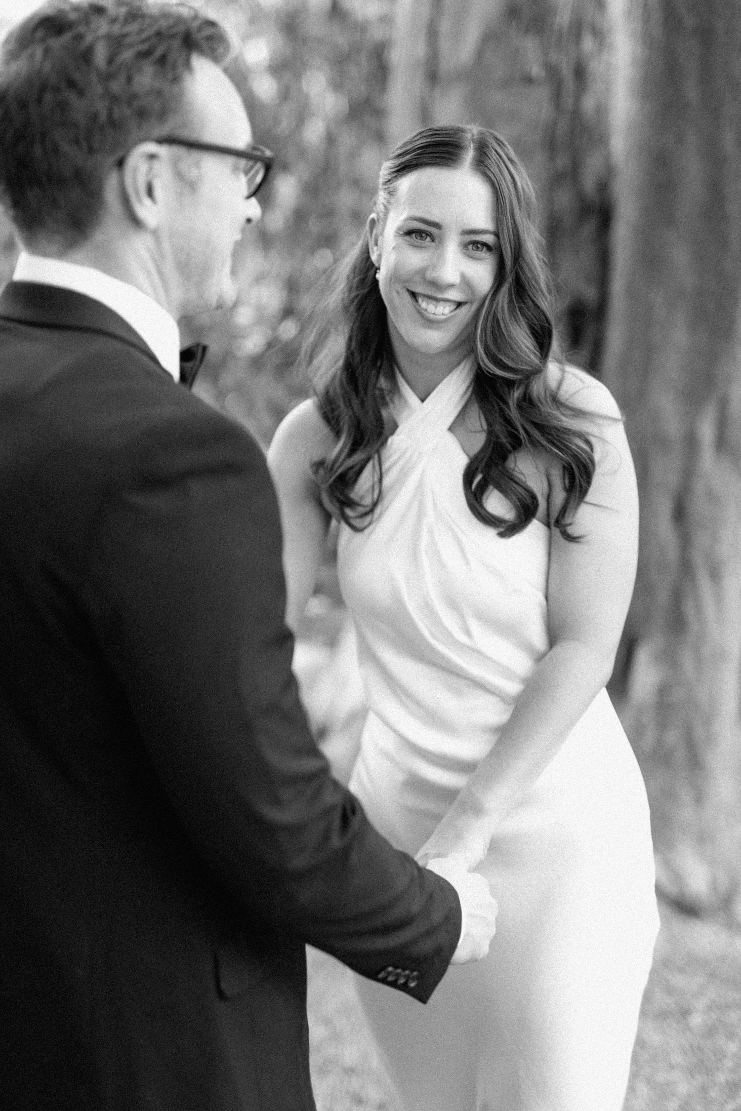 Black-and-white detail of Lloyd holding Brooke around the waist as they embrace.