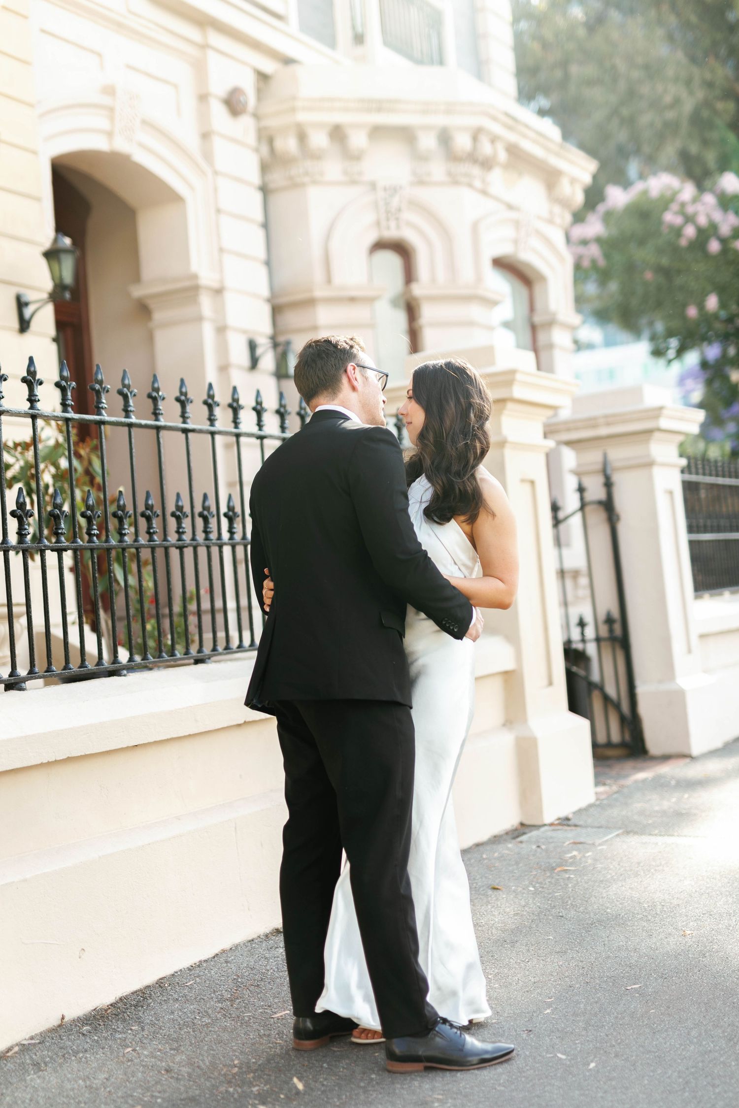 Brooke and Lloyd embracing beside a heritage building on North Terrace, Adelaide