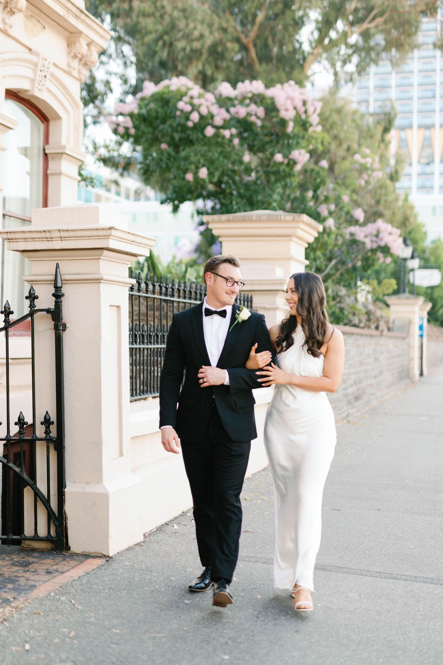 Brooke and Lloyd walking together past heritage buildings on North Terrace, Adelaide