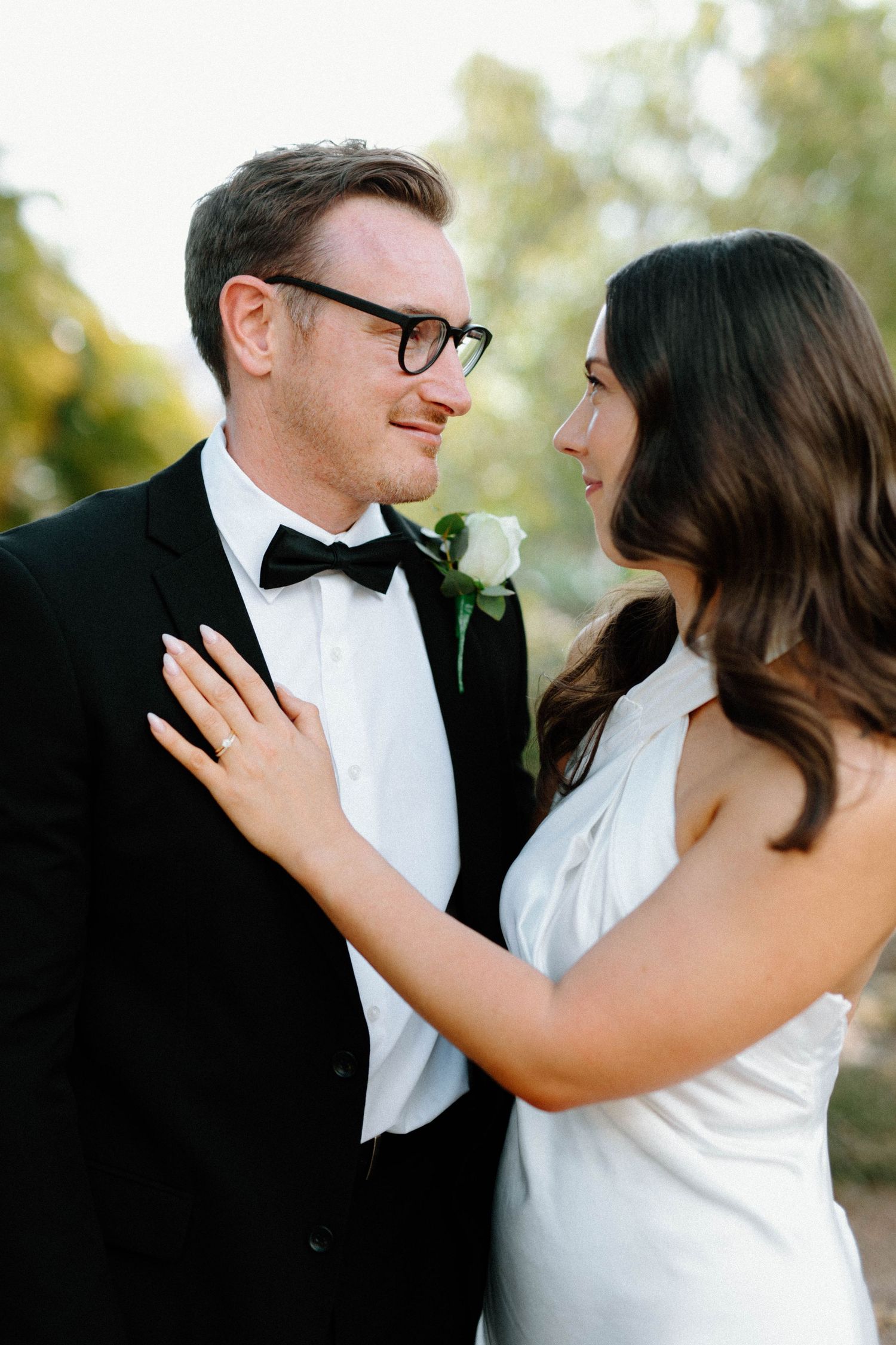 Brooke and Lloyd embracing on a leafy path during their Adelaide Botanic Garden elopement.