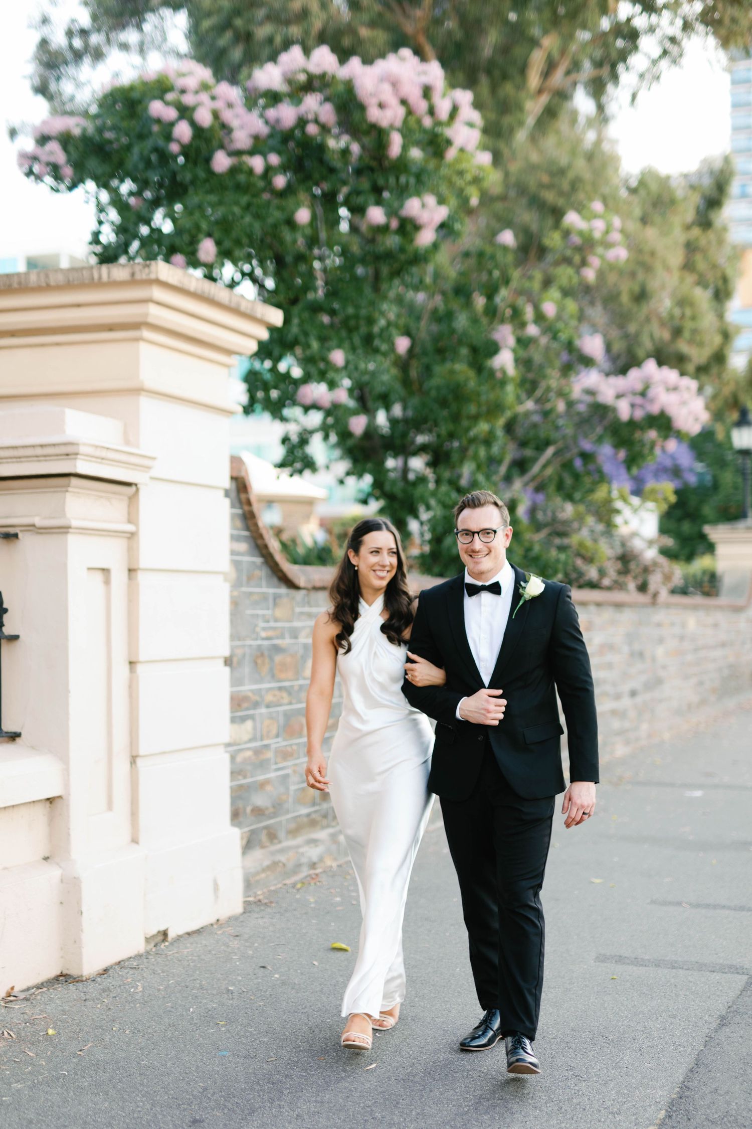 Brooke and Lloyd walking together beneath the trees on North Terrace.