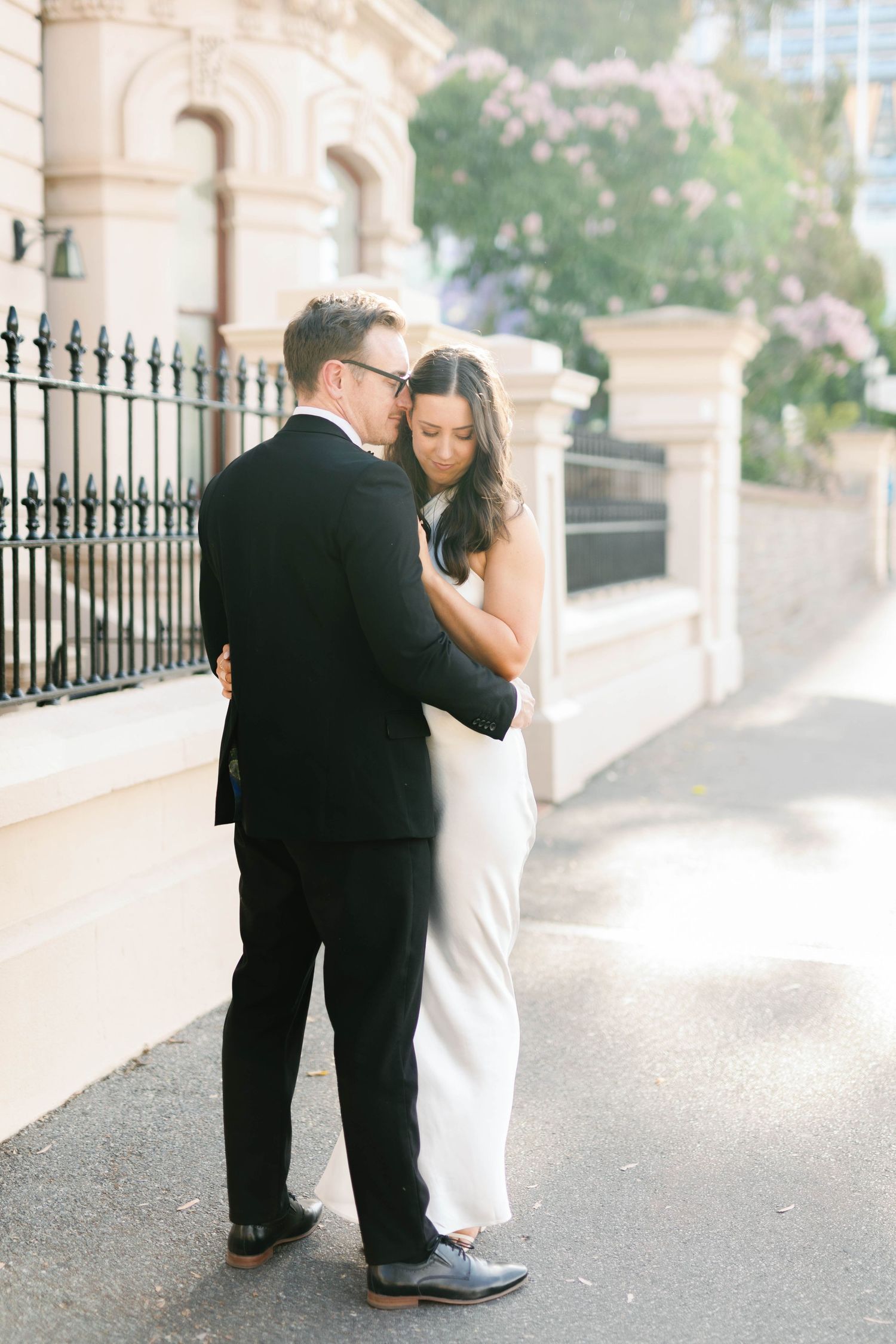 Brooke and Lloyd embracing beside a heritage building on North Terrace, Adelaide