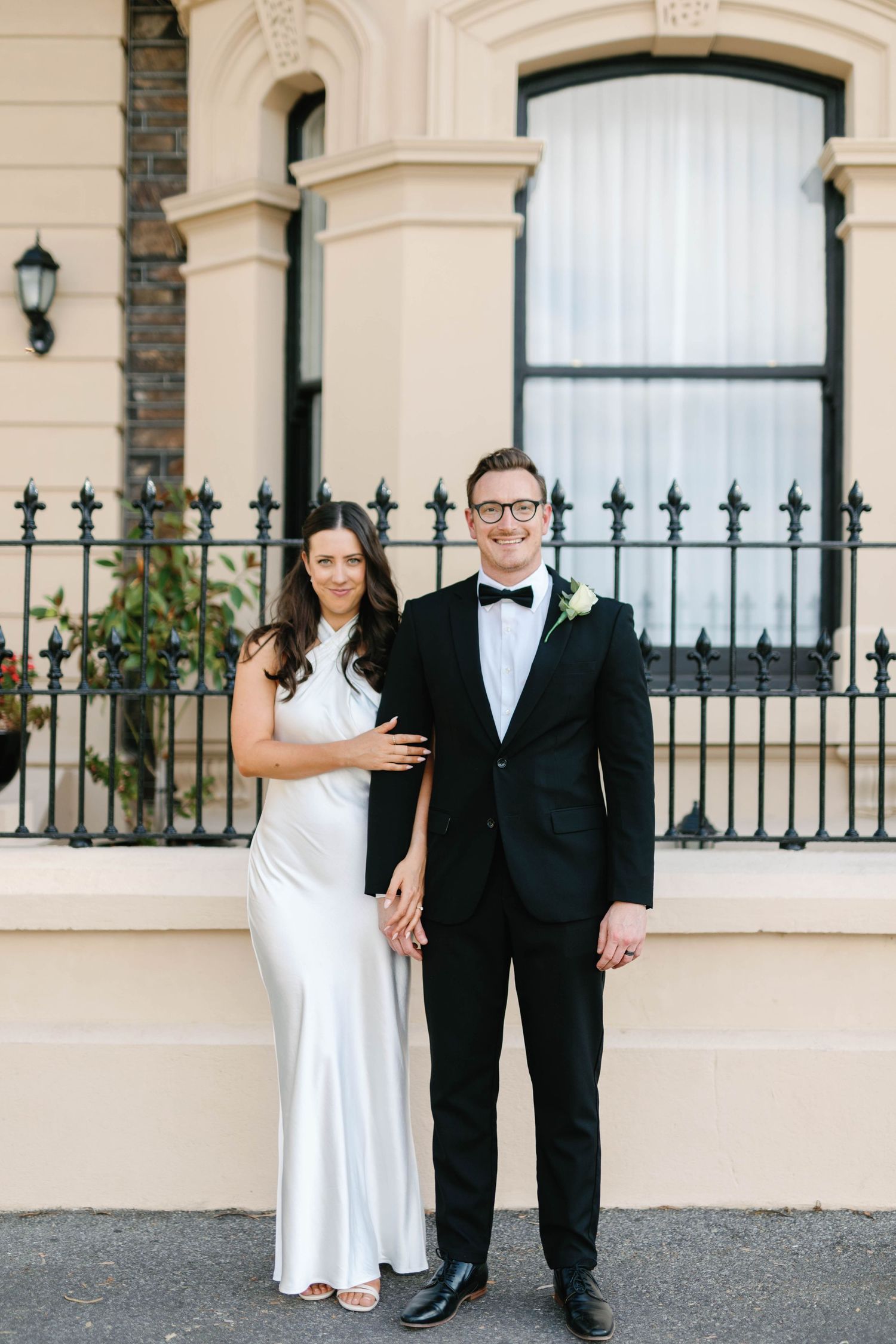 Full-length portrait of Brooke and Lloyd beside a wrought iron fence in Adelaide