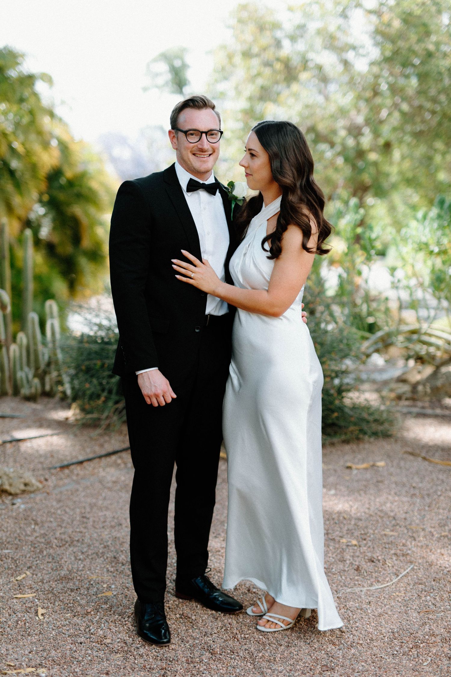 Brooke and Lloyd embracing on a leafy path during their Adelaide Botanic Garden elopement.